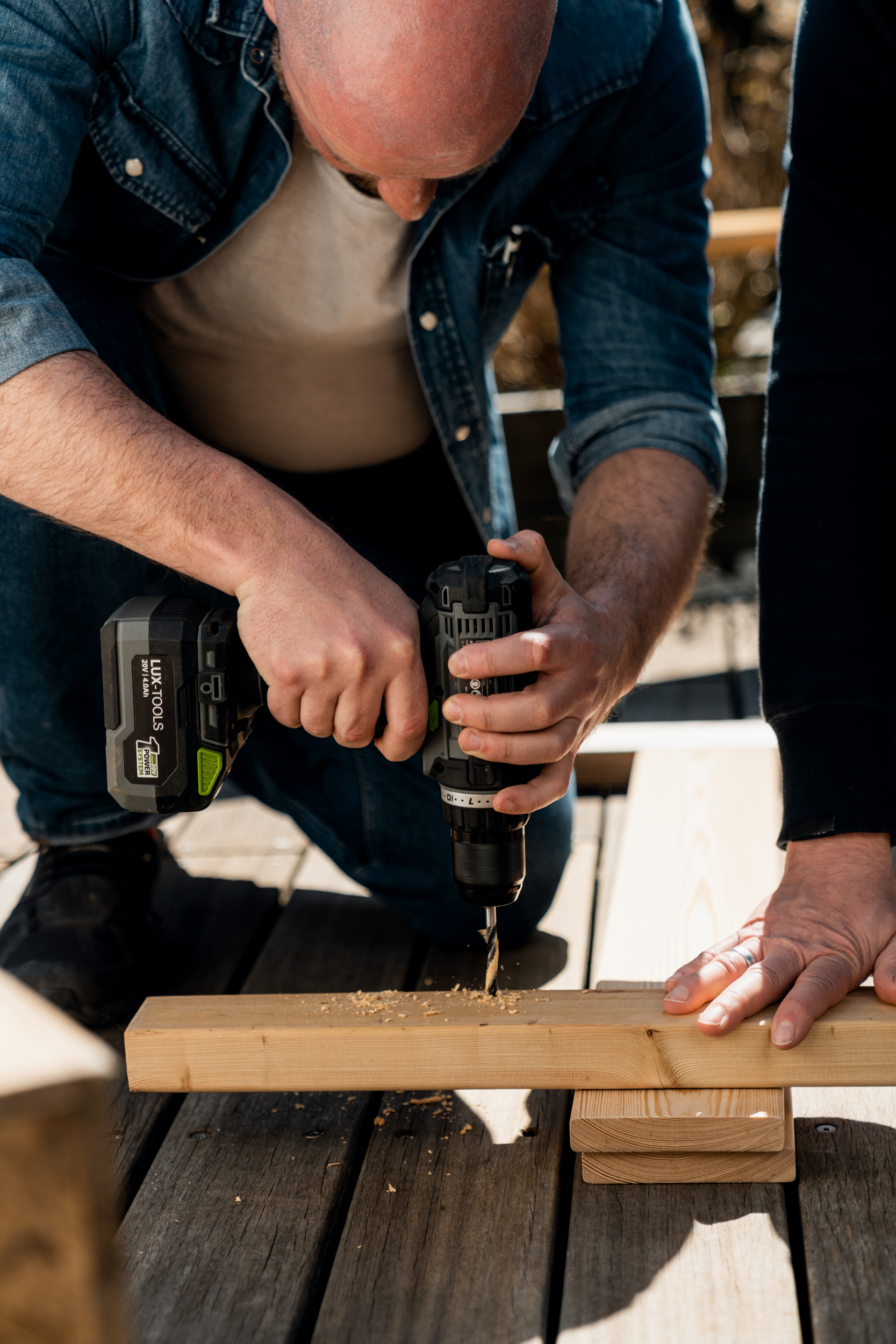 Una persona realizza un foro nel listello di legno
