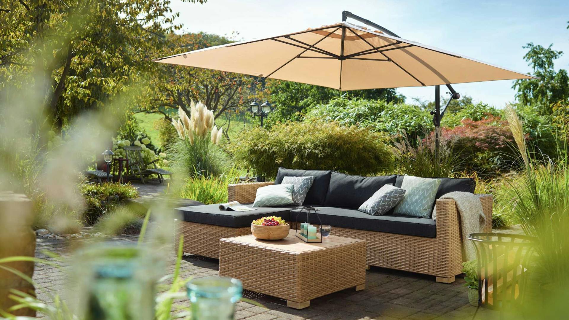 Terrazza moderna con pavimento in assi in legno, gruppo lounge e decorazioni