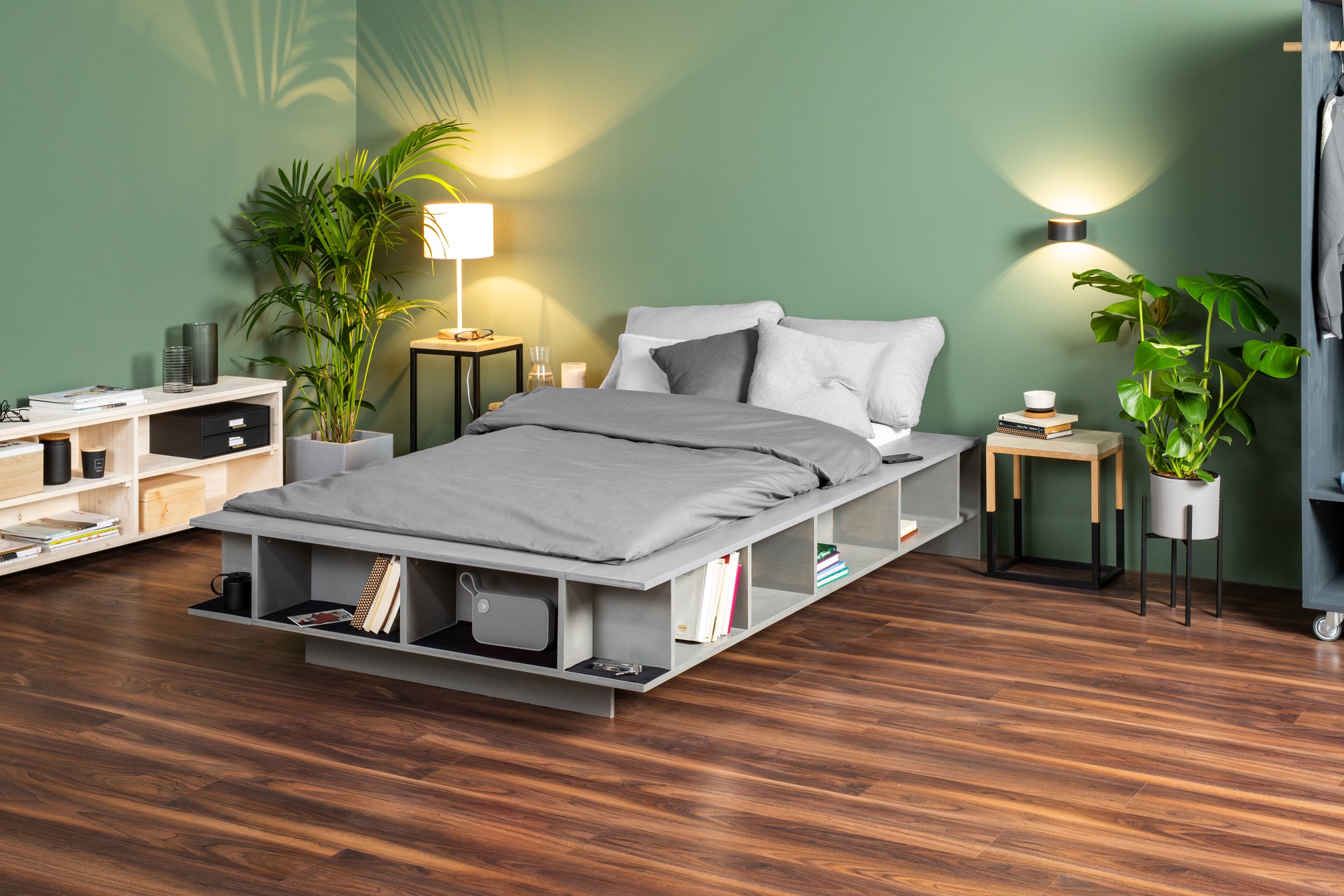 Lit DIY avec rangements sur plancher en bois foncé dans une chambre à coucher