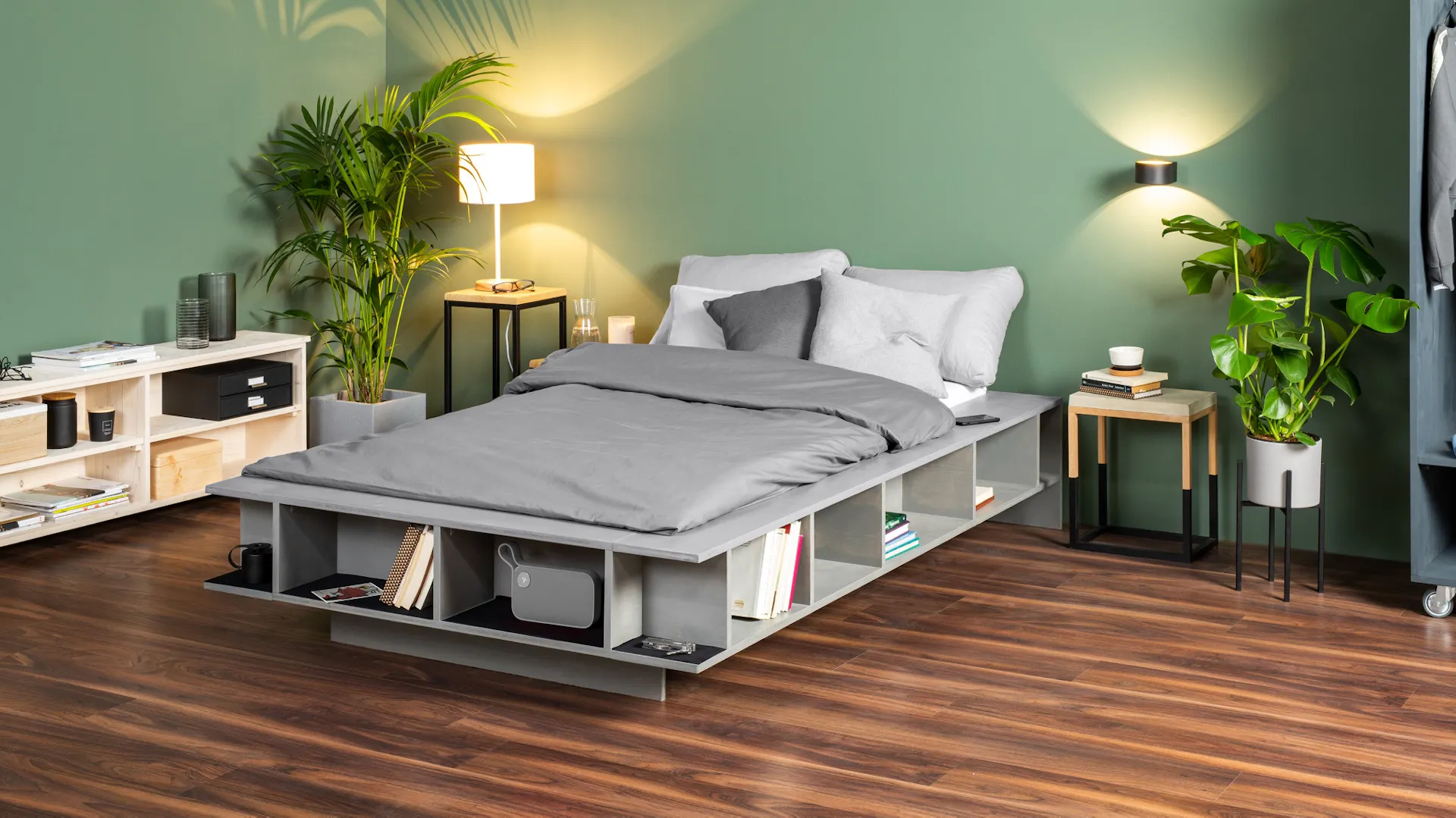 Lit DIY avec rangements sur plancher en bois foncé dans une chambre à coucher