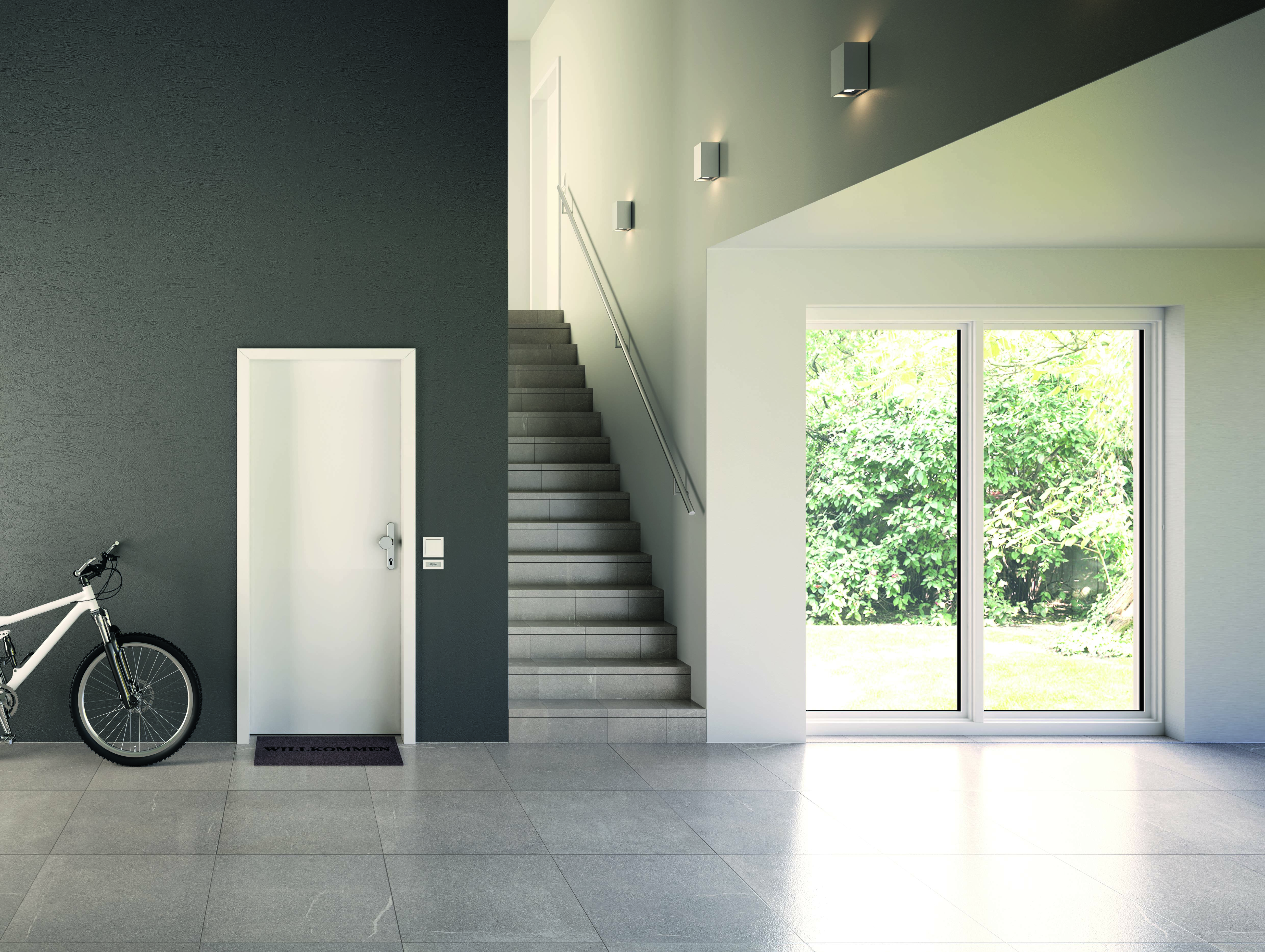 Façade de fenêtre et porte d'appartement à côté d'un escalier dans une construction neuve