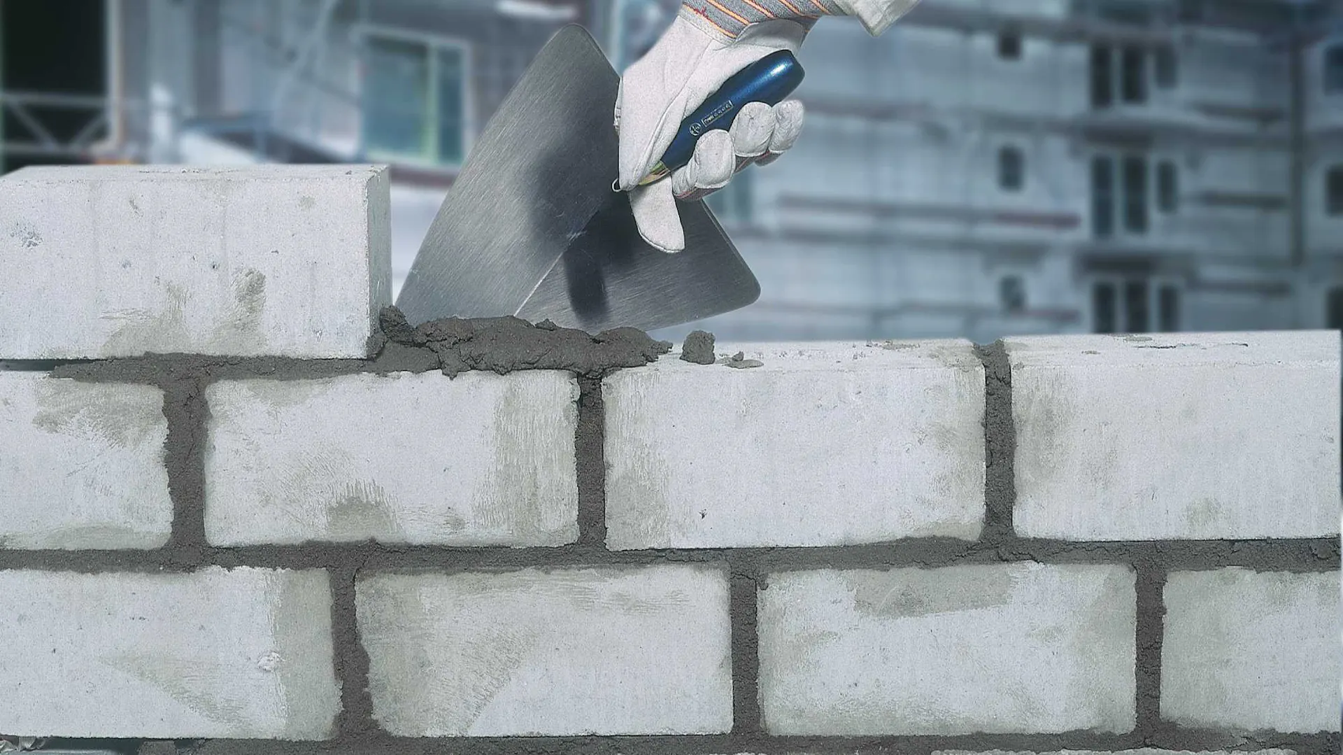 Construction d'un mur de briques avec truelle et ciment