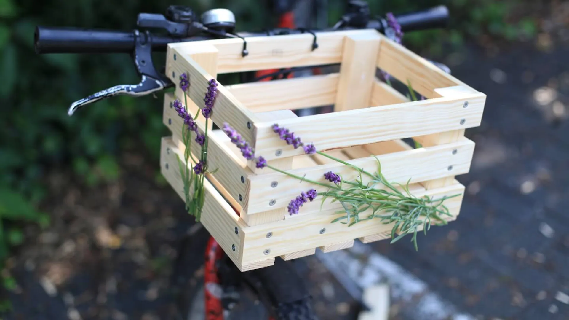 Fahrrad mit einer Holzkiste, diese ist verziert mit Blumen.
