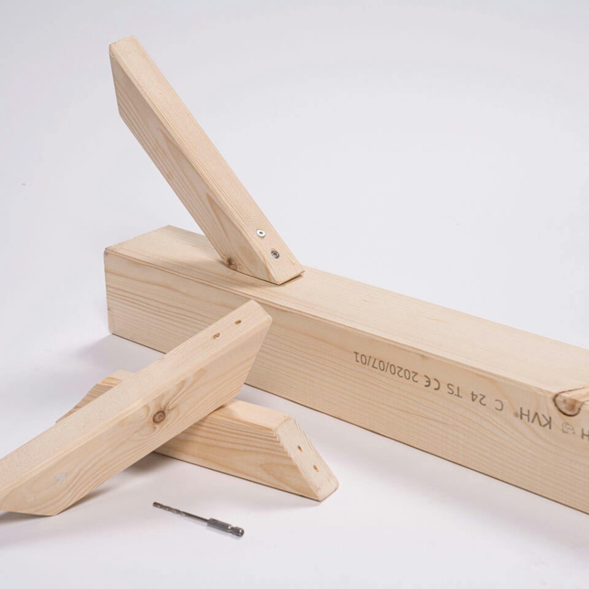 Zwei Holzstücke neben einer Holzlatte, ein Holzstück angeschraubt