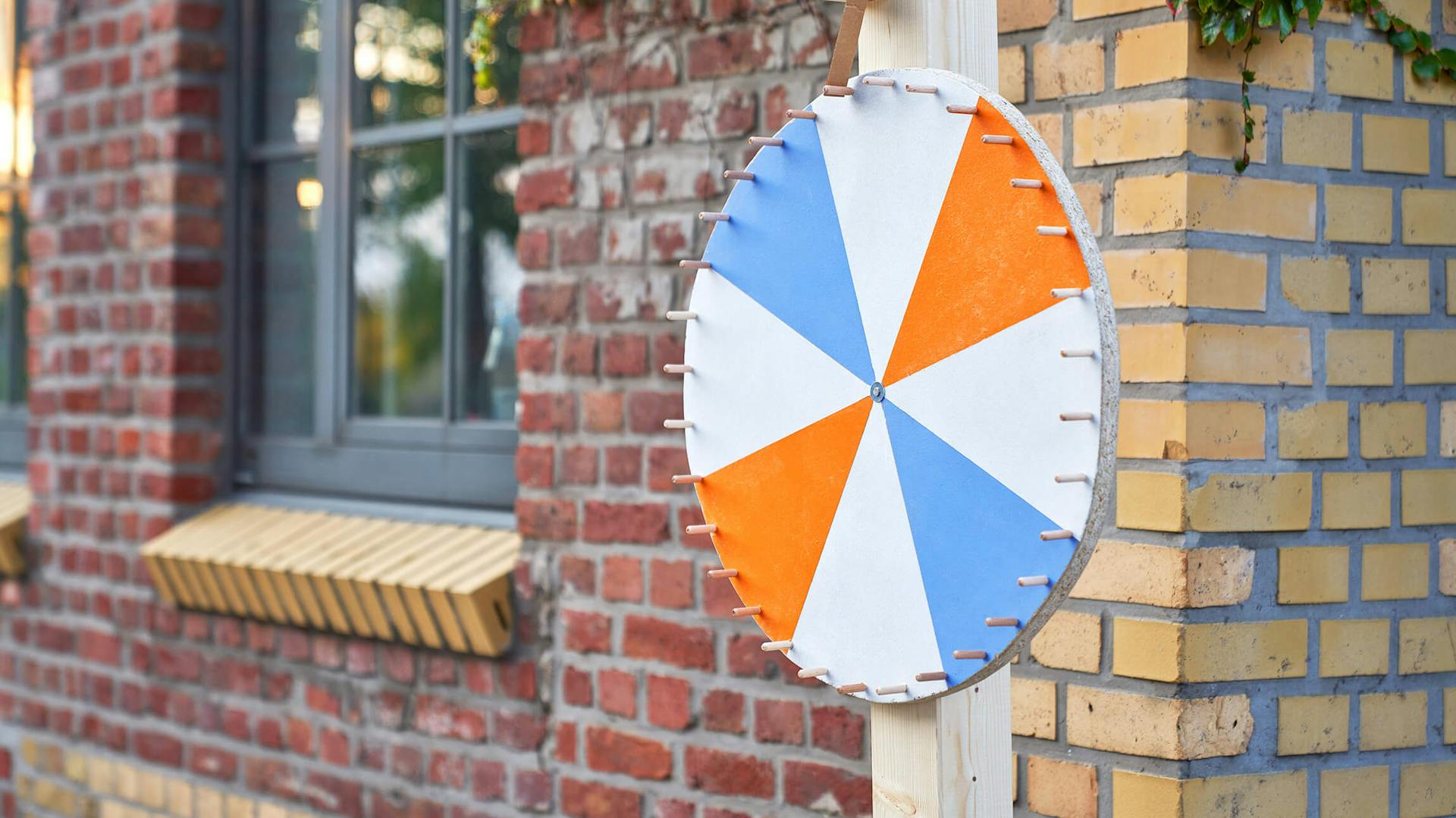 Glücksrad steht vor Ziegelsteinmauer