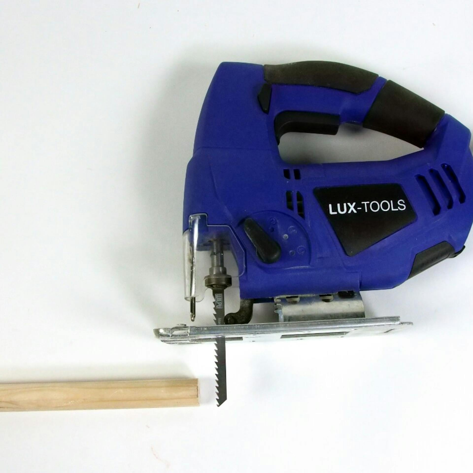 Es ist ein Rundstab aus Holz zu sehen. Daneben liegt eine blaue Stichsäge.