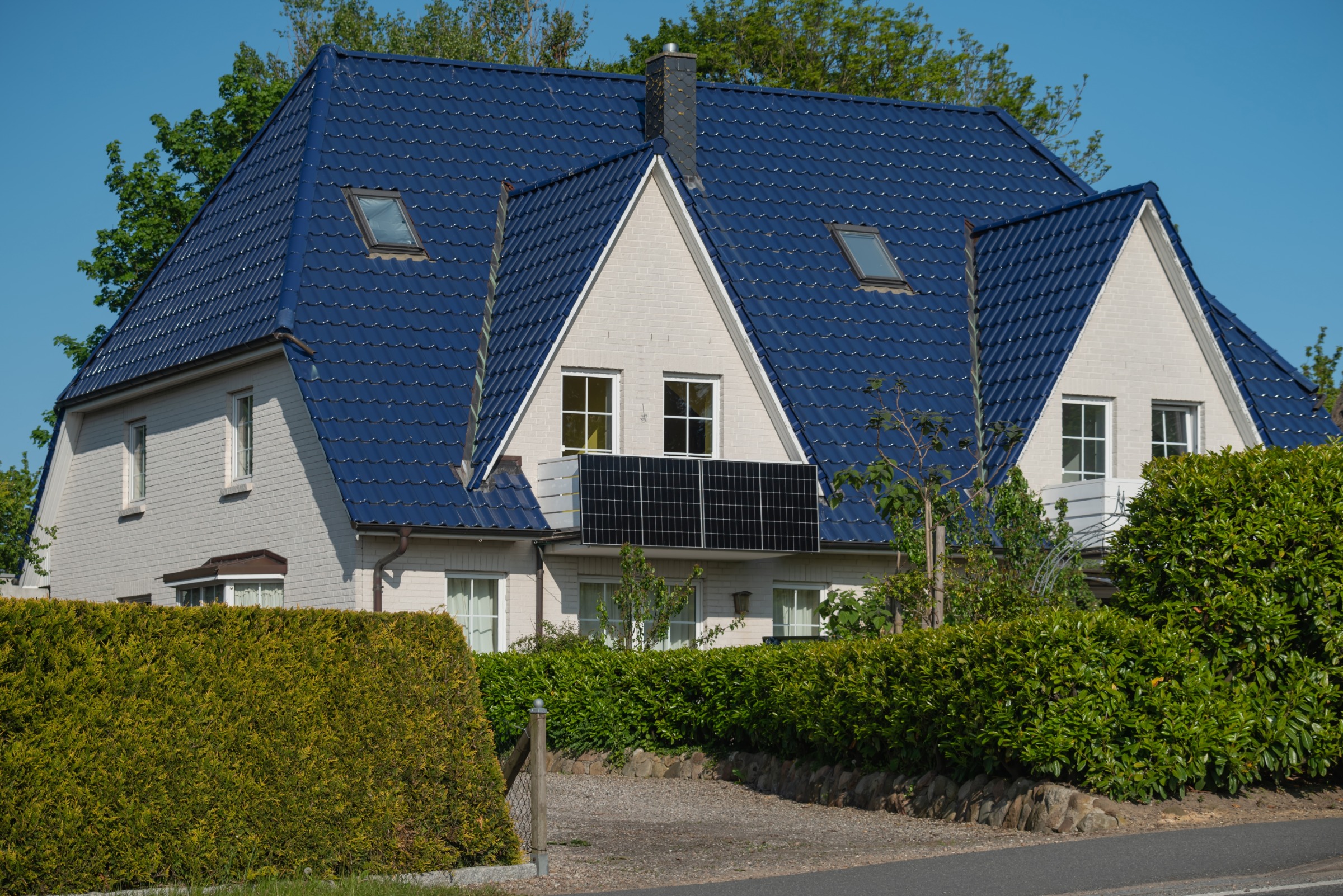 Weißes Haus mit Solarpanels am Balkon