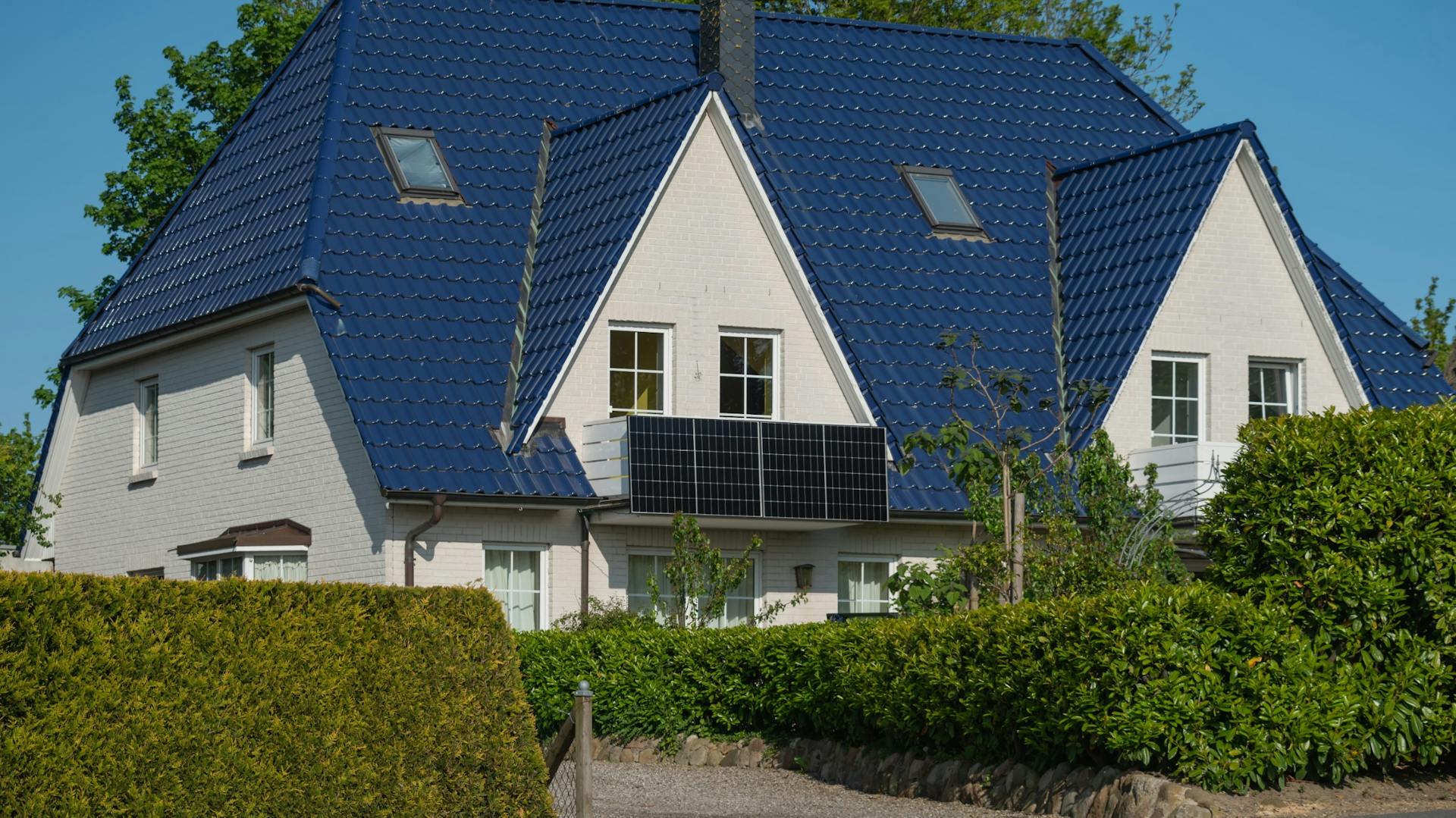 Weißes Haus mit Solarpanels am Balkon