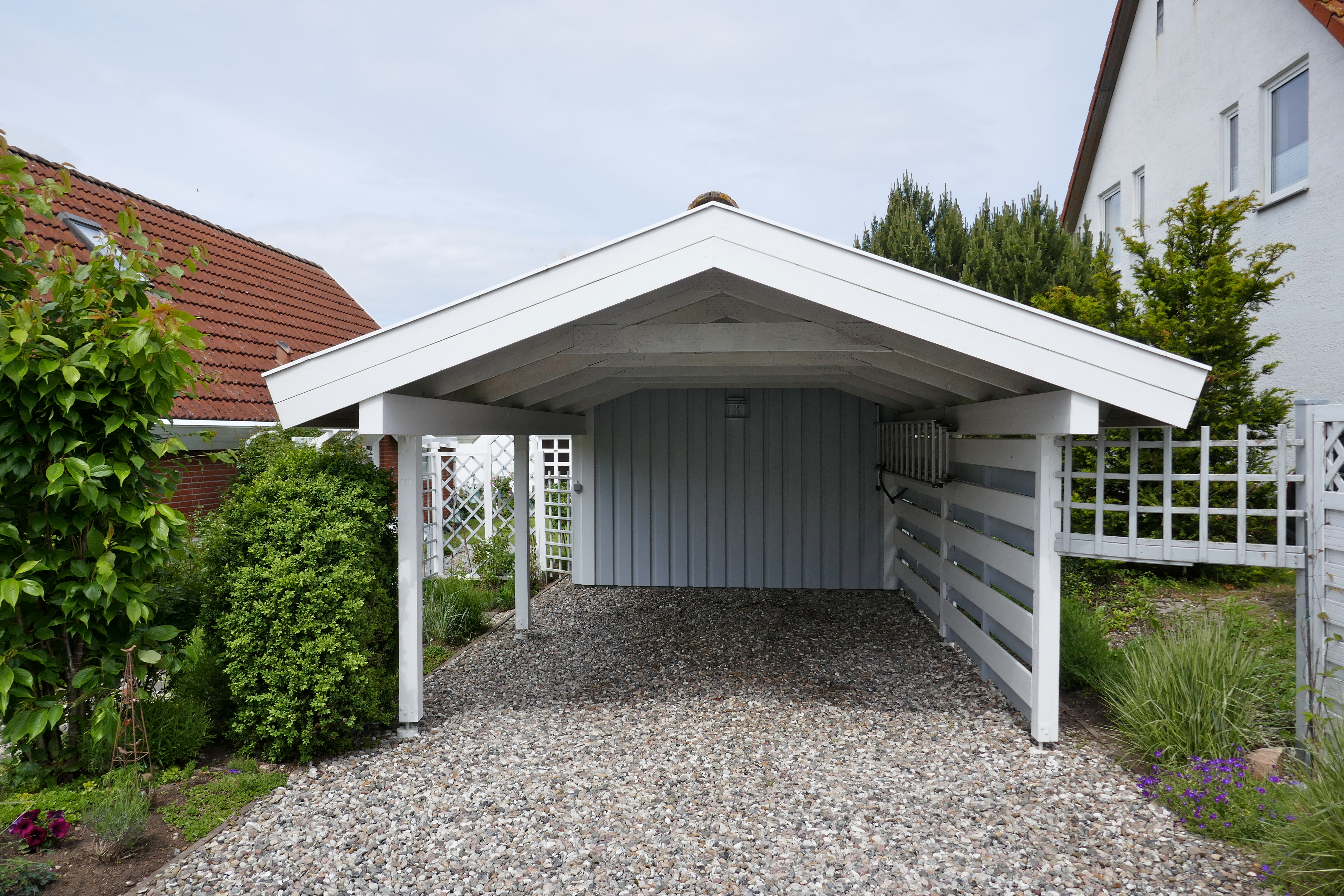 Carport mit Holzelementen als Seitenwand