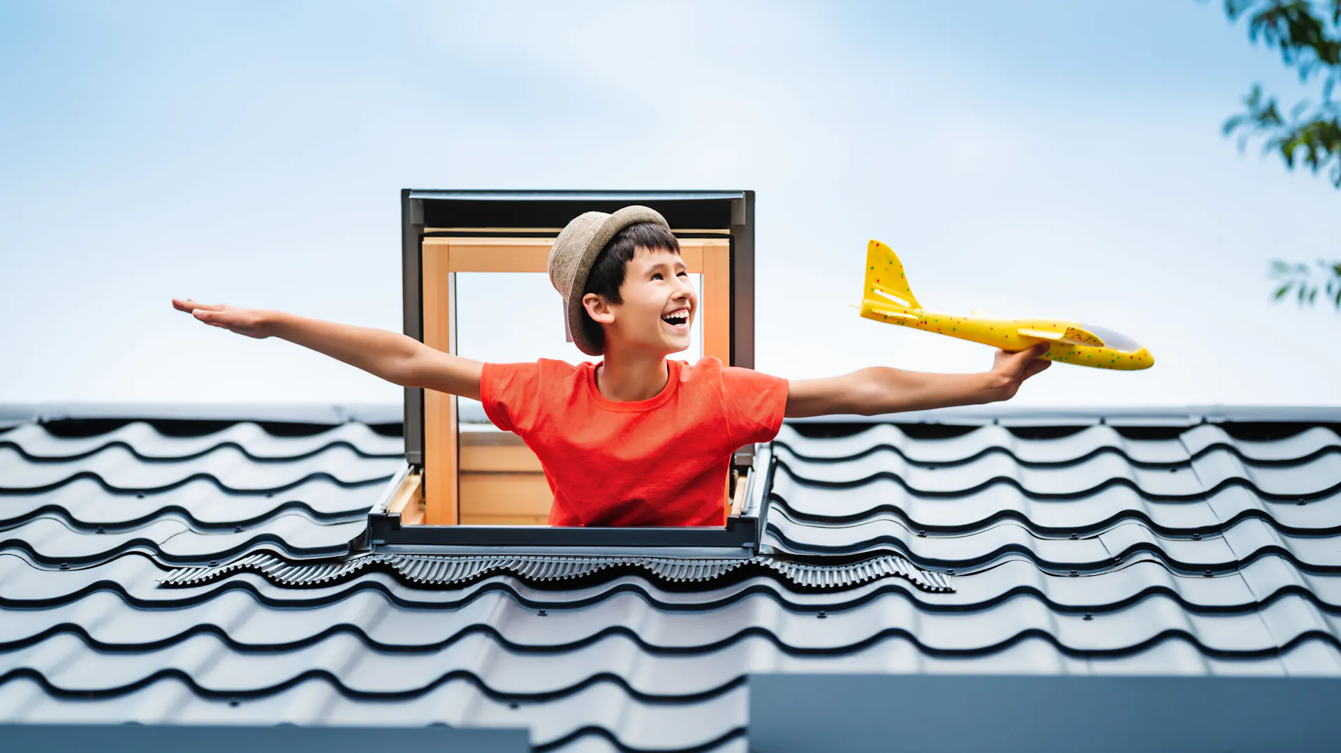 Junge schaut aus einem Dachfenster