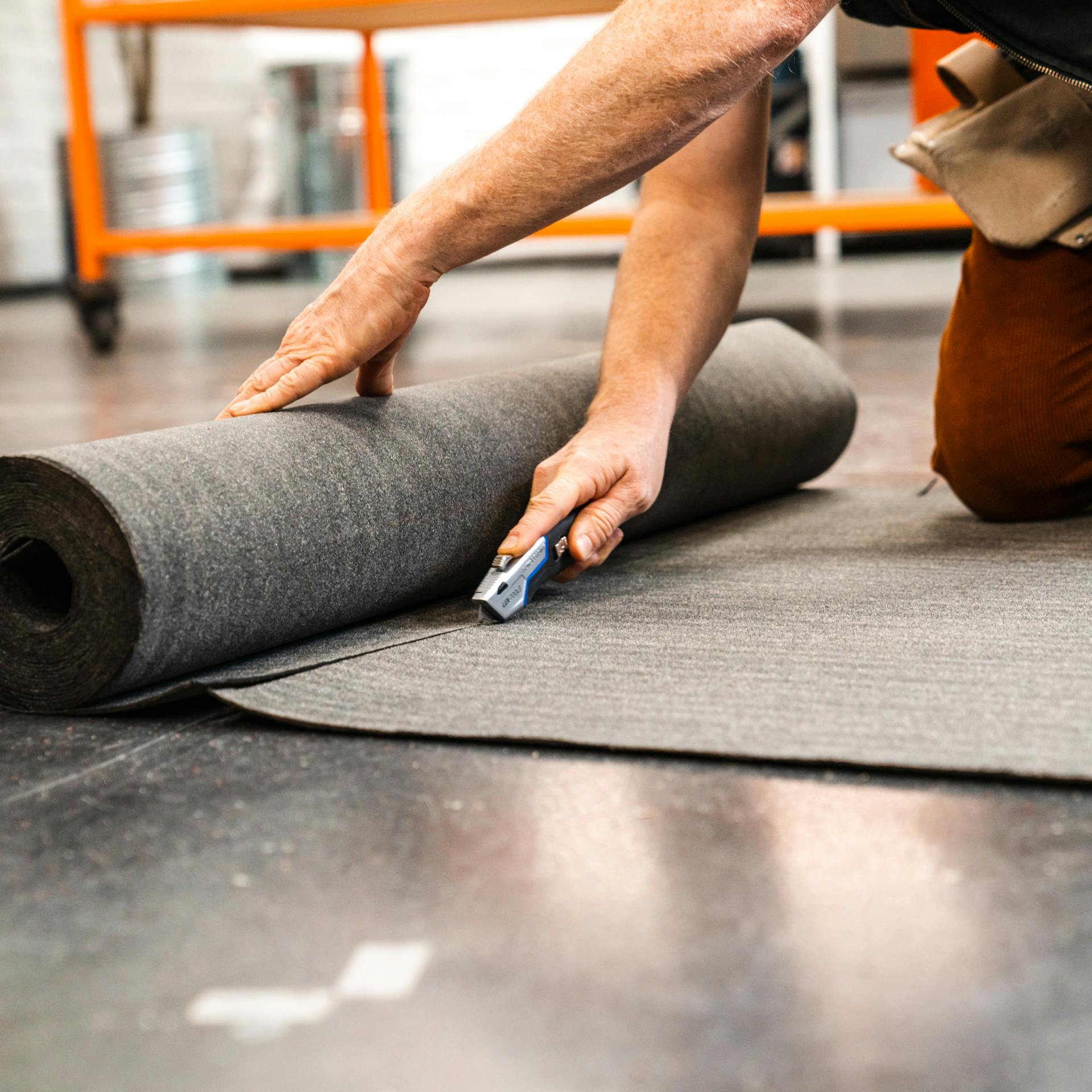 Dachpappe wird mit dem Cuttermesser zugeschnitten