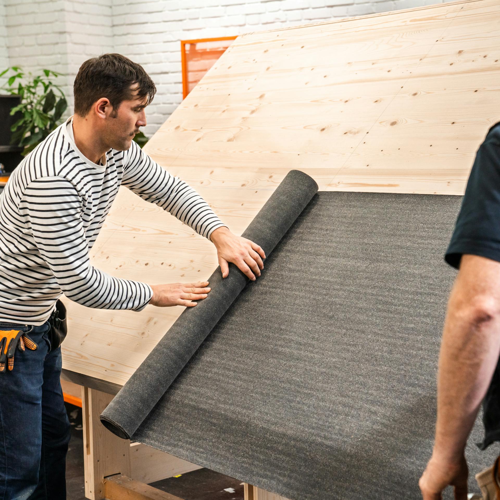 Dachpappe wird auf dem Dach ausgerollt