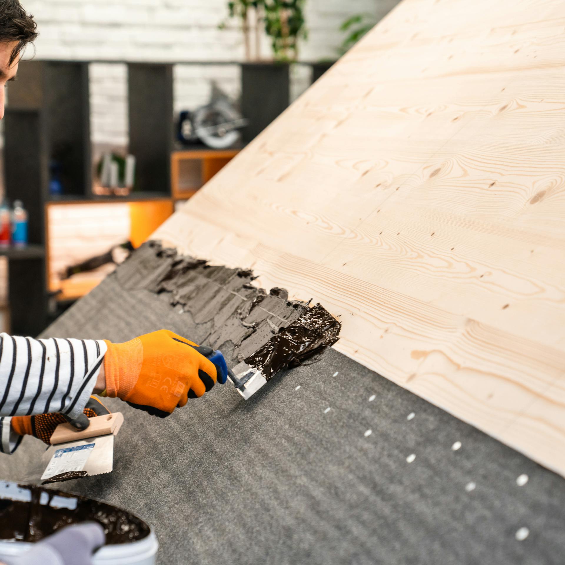 Bitumenkleber wird auf das Dach aufgetragen