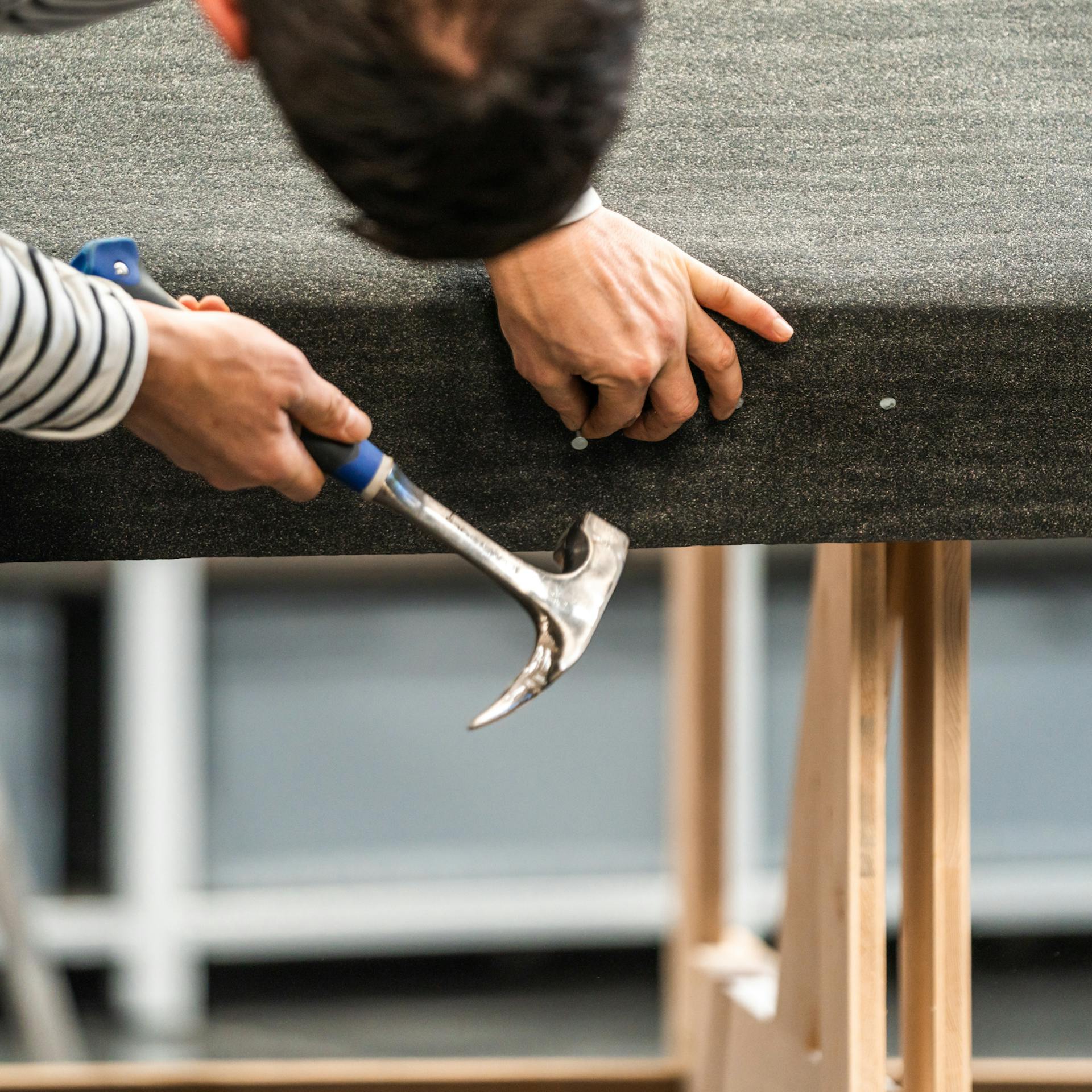 Die Unterkante des Daches wird mit Dachpappenstiften vernagelt