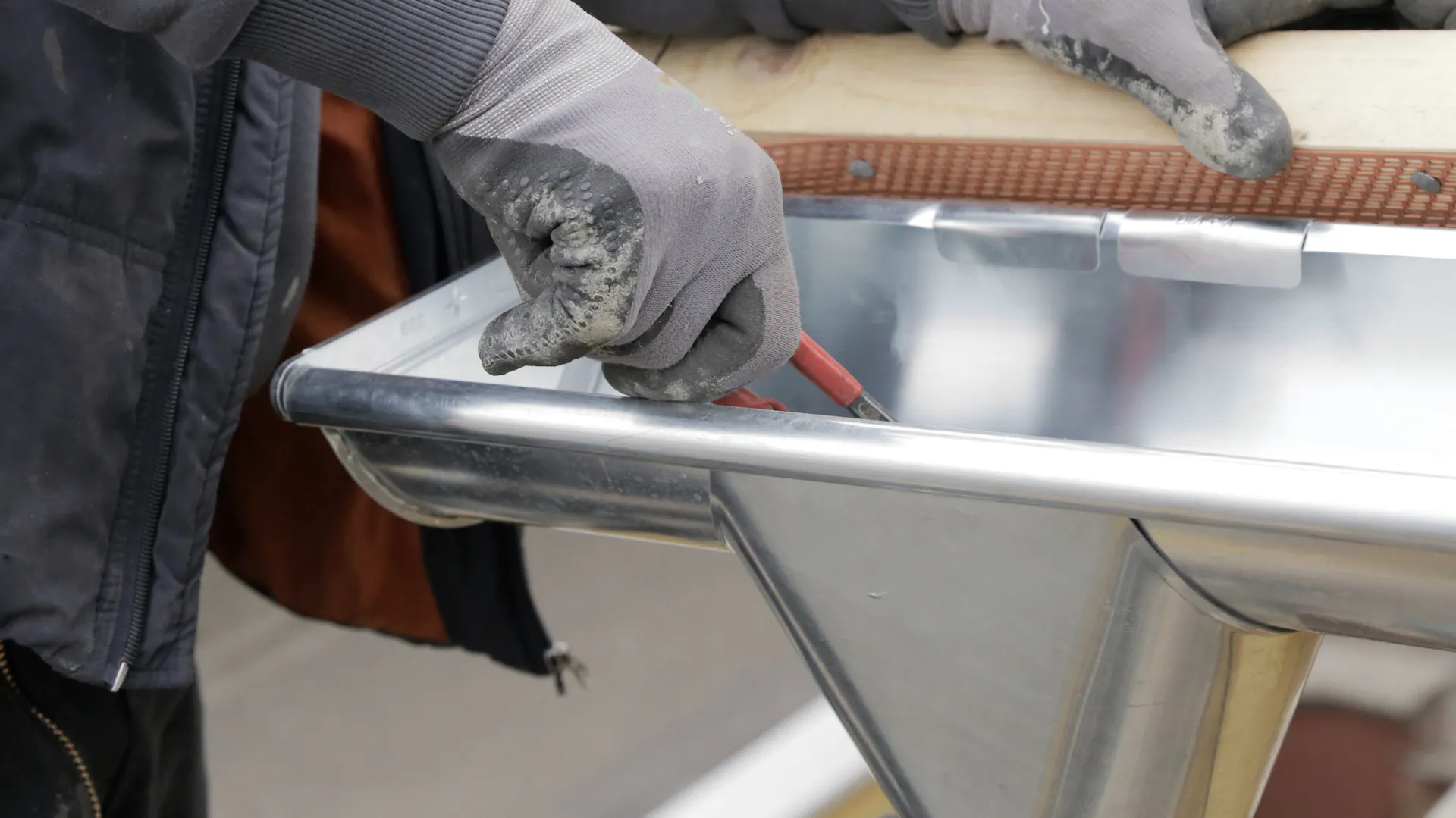 Egy barkácsoló előkészíti az ereszcsatorna szigetelését.