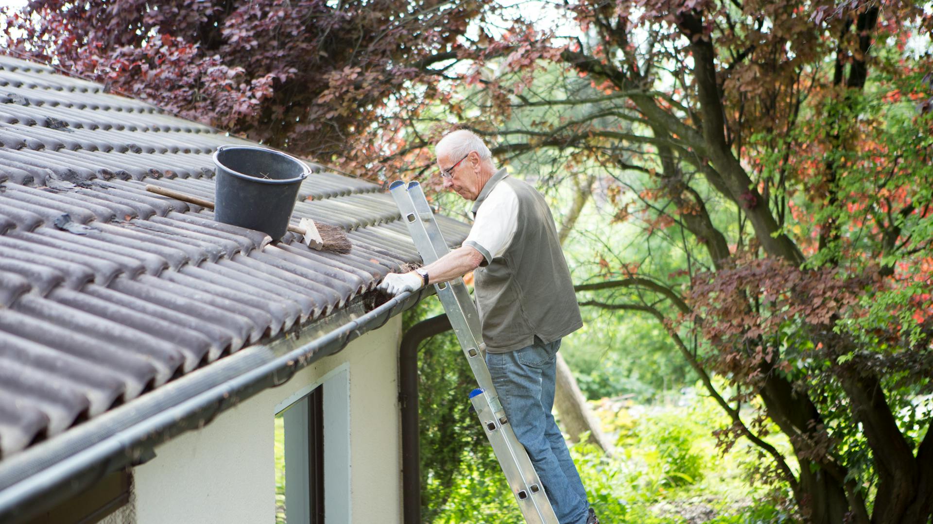 Egy férfi ereszcsatornát tisztít