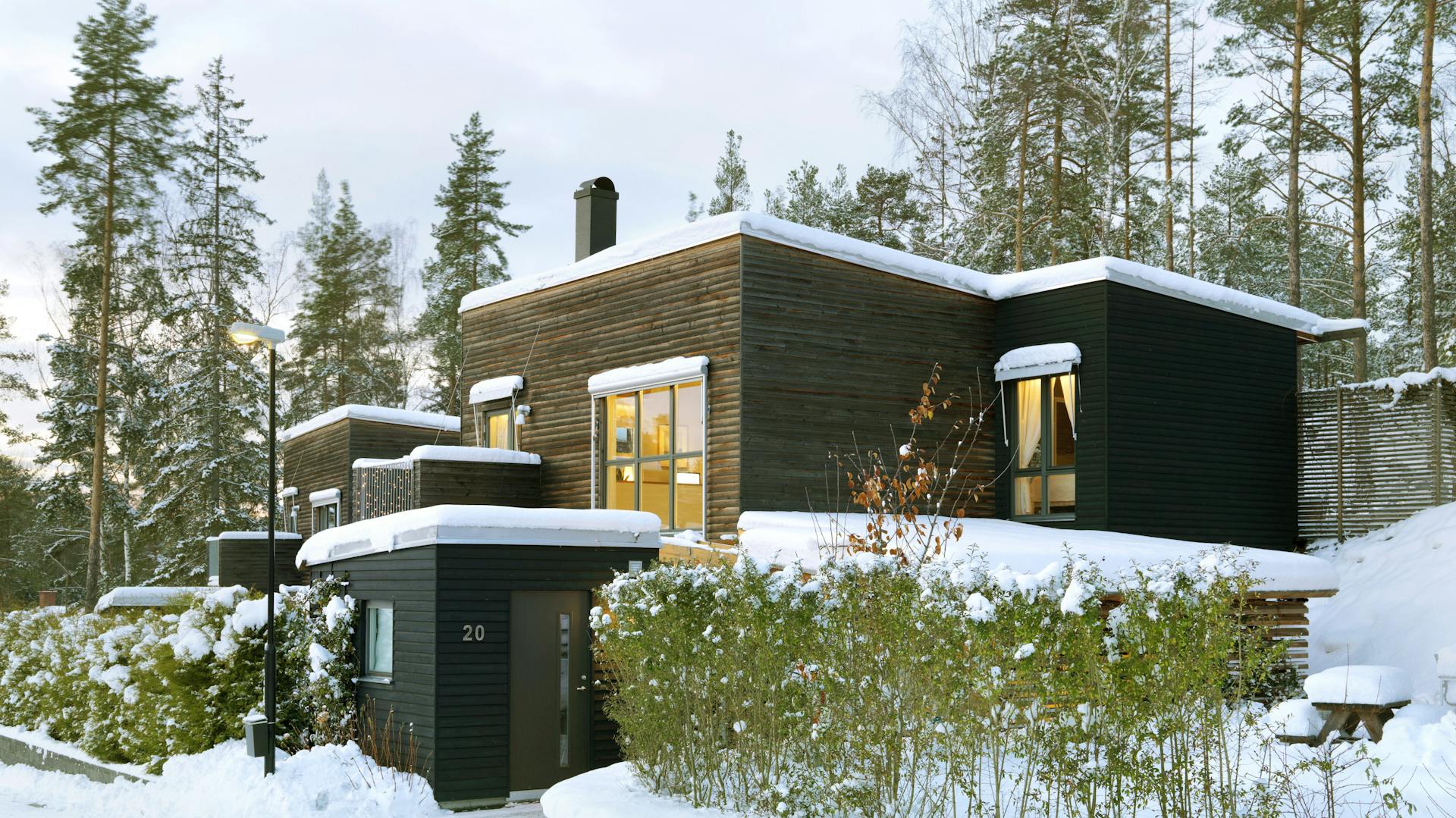 Haus mit Flachdach, das mit Schnee bedeckt ist.