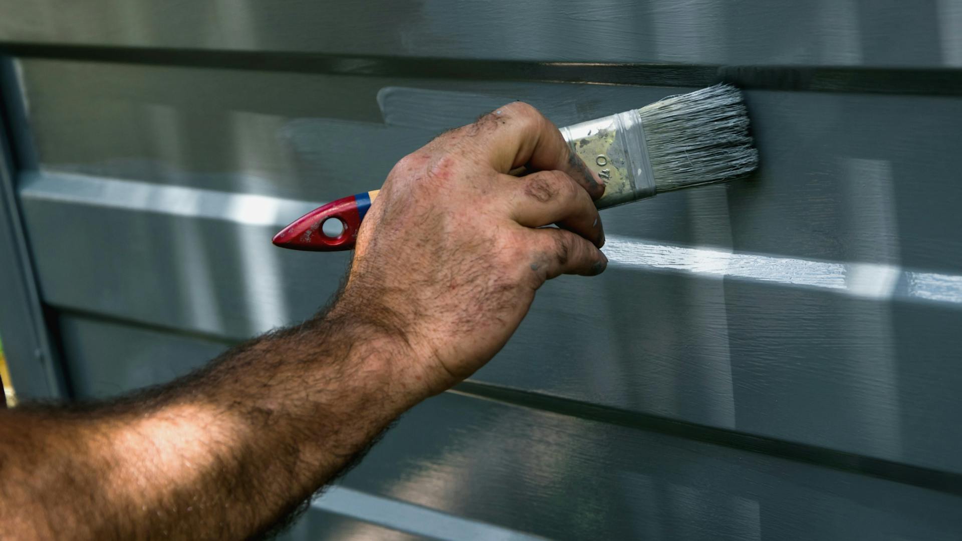 Jemand lackiert ein Garagentor