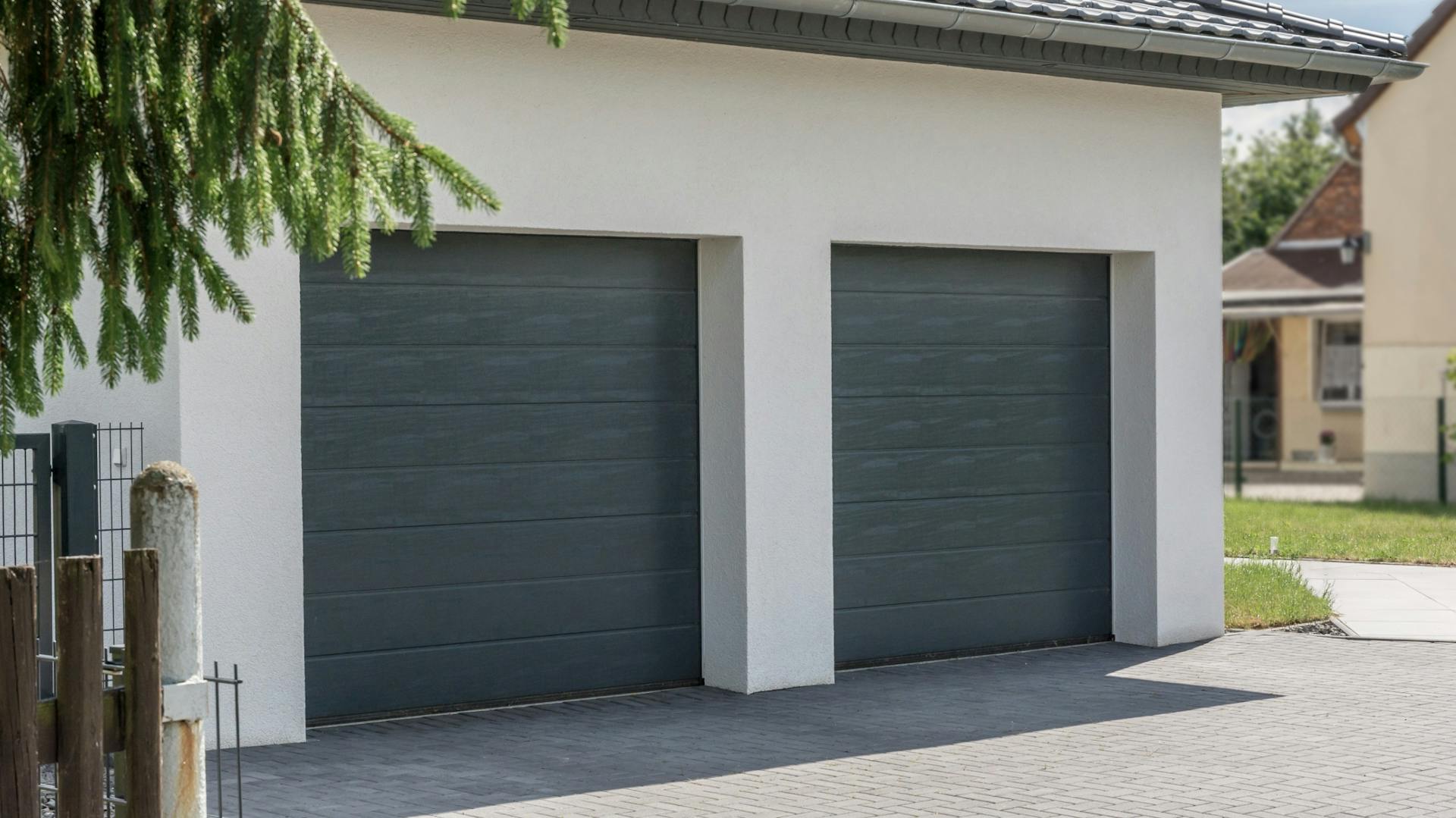 Doppelgarage an einem weißen Haus.