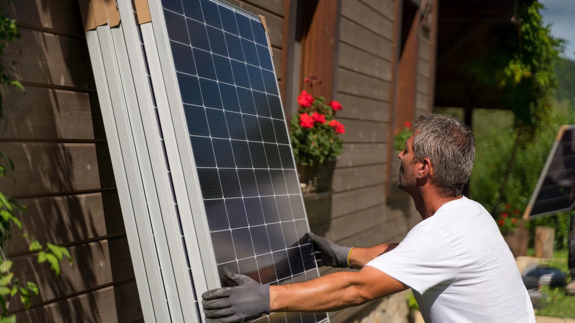 Ein Mann hebt ein Photovoltaik-Panel an