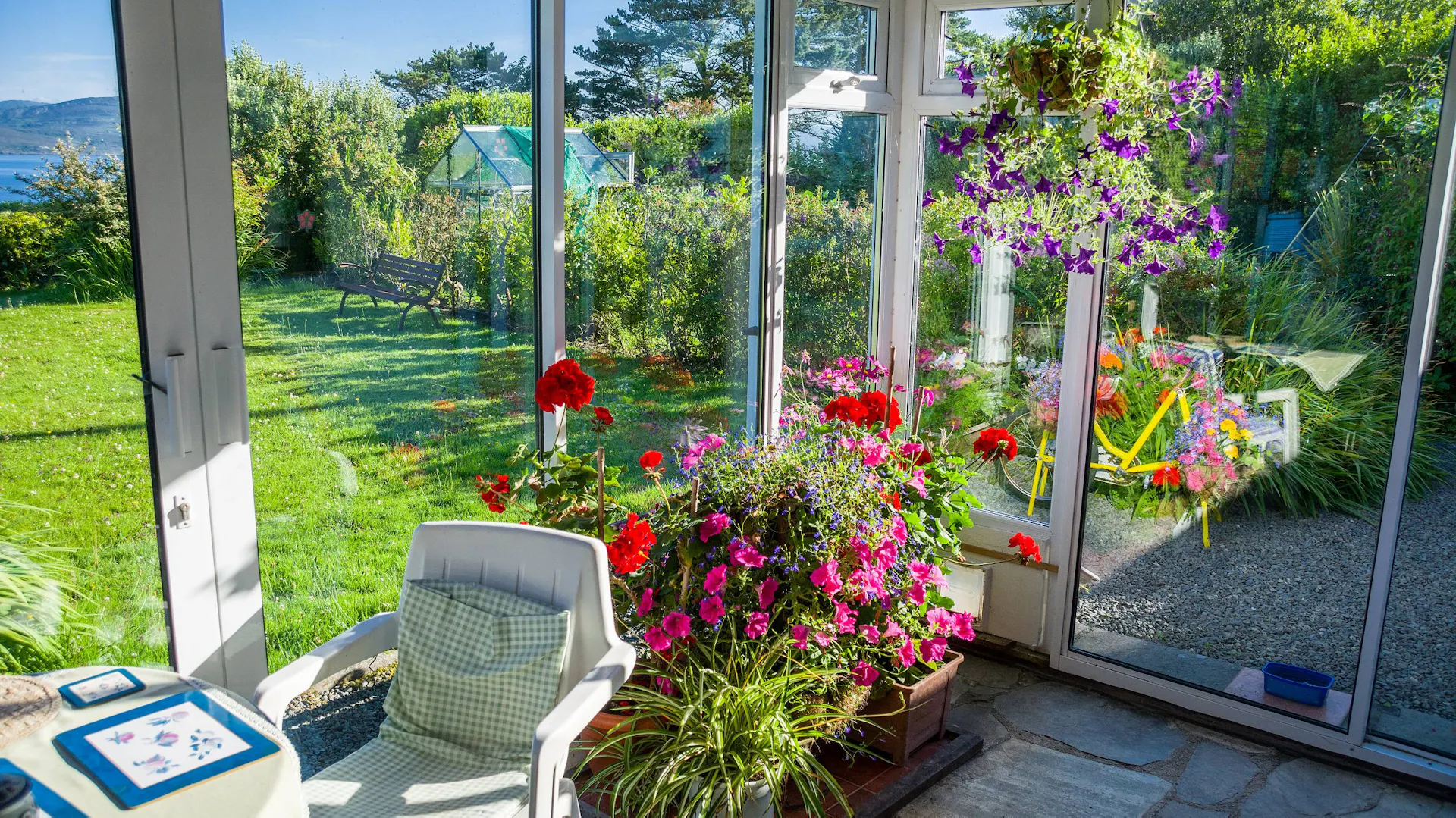 Weiße Gartenmöbel und Blühpflanzen im Sommergarten