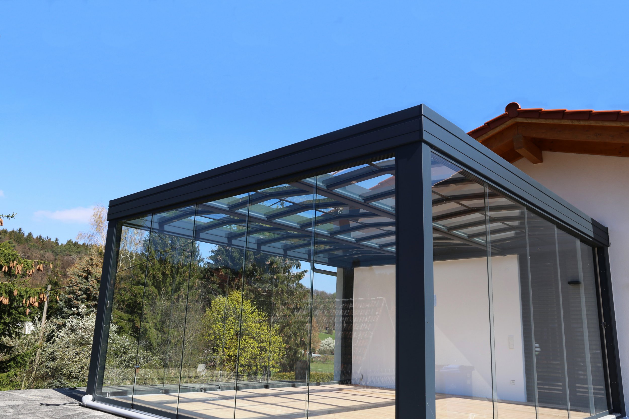 Leerer Sommergarten mit Glasfronten