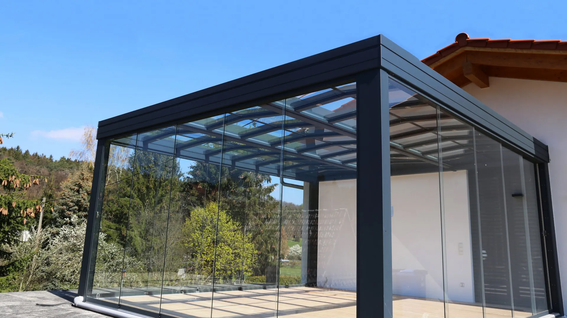 Leerer Sommergarten mit Glasfronten