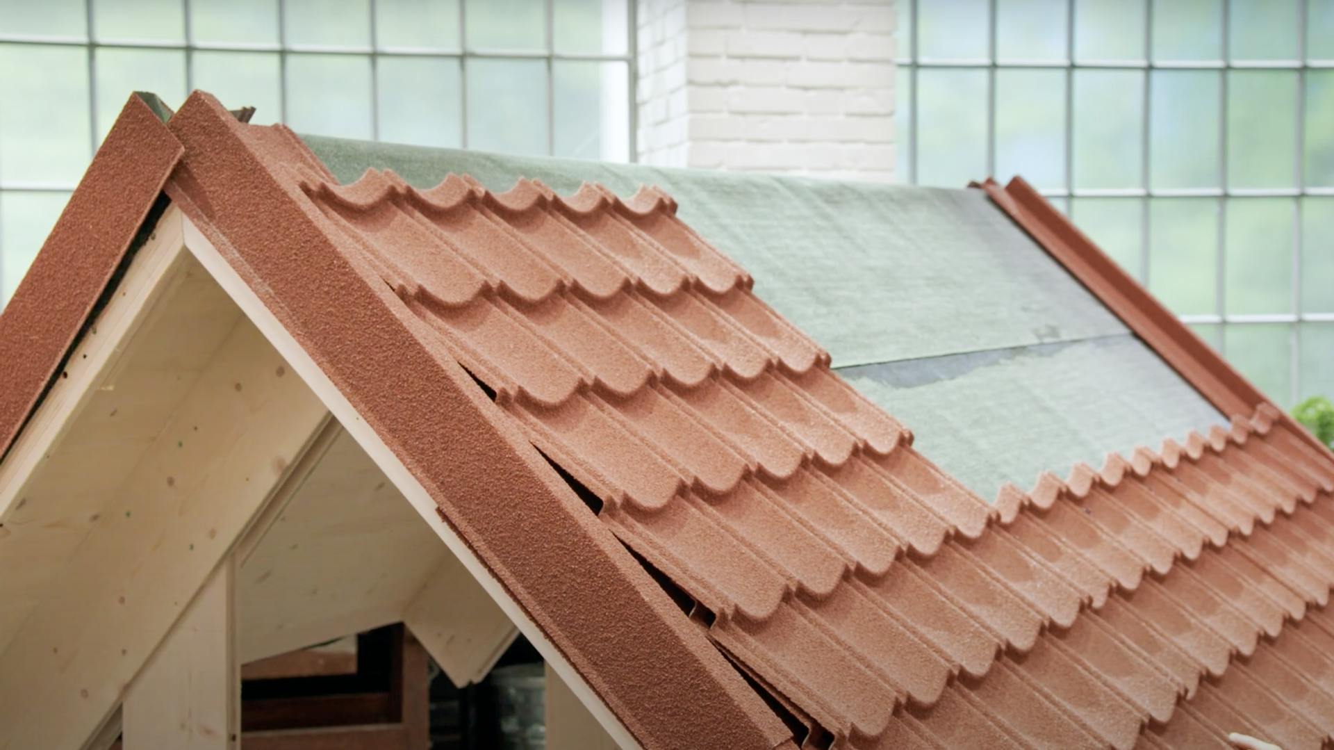 Ein Dach auf dem rötliche Pfannenbleche verlegt wurden.