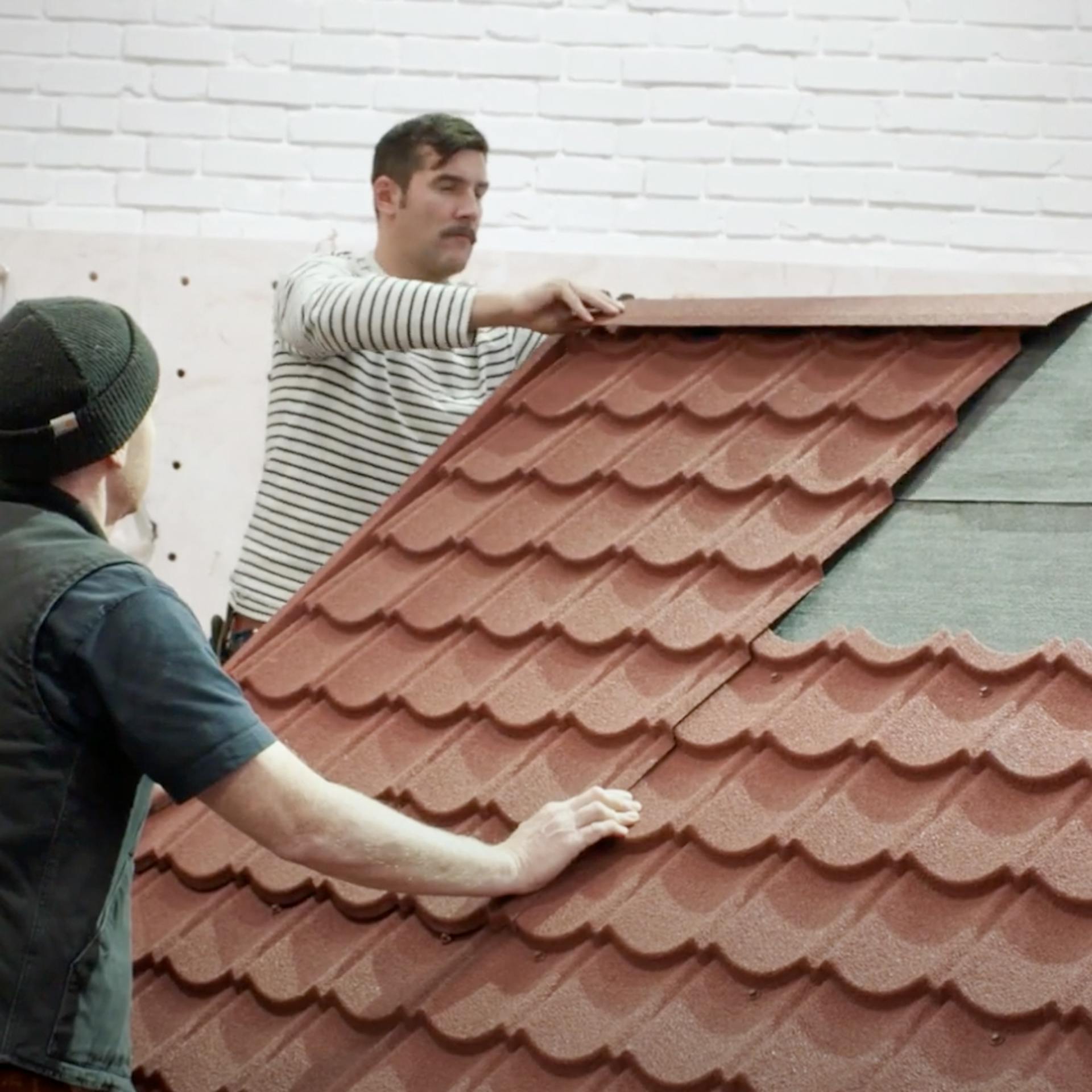Handwerker verlegen die Pfannenbleche auf dem Dach.
