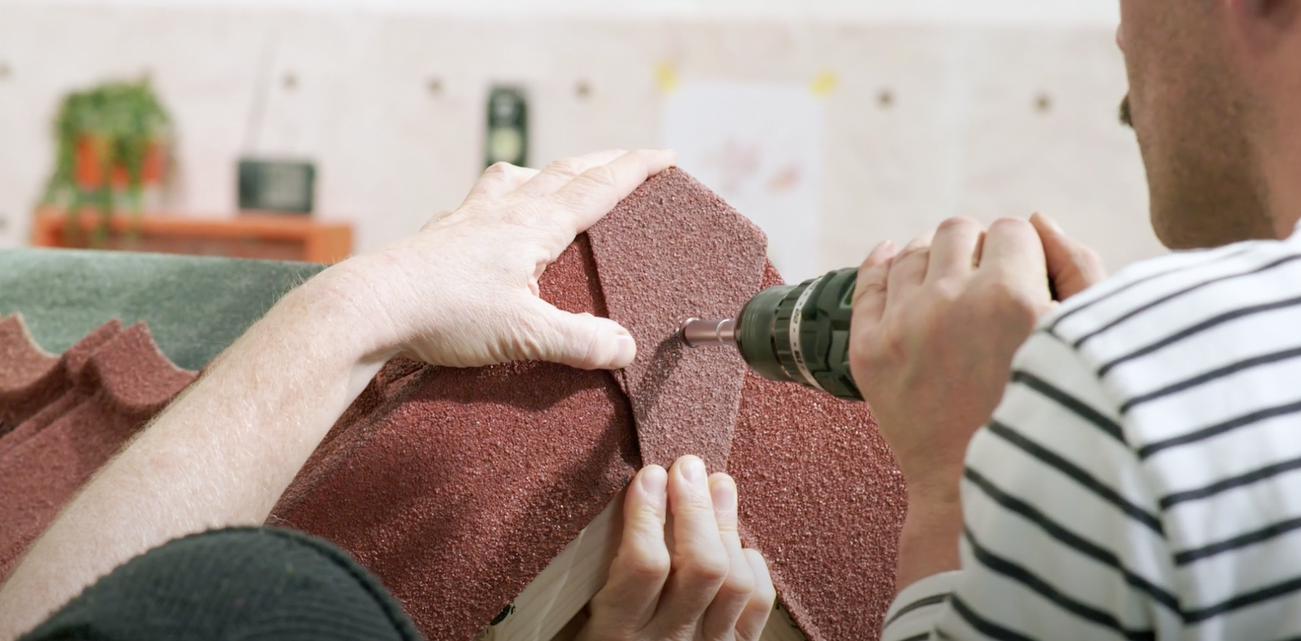 Handwerker verschrauben das Endstück des Ortgangprofils.