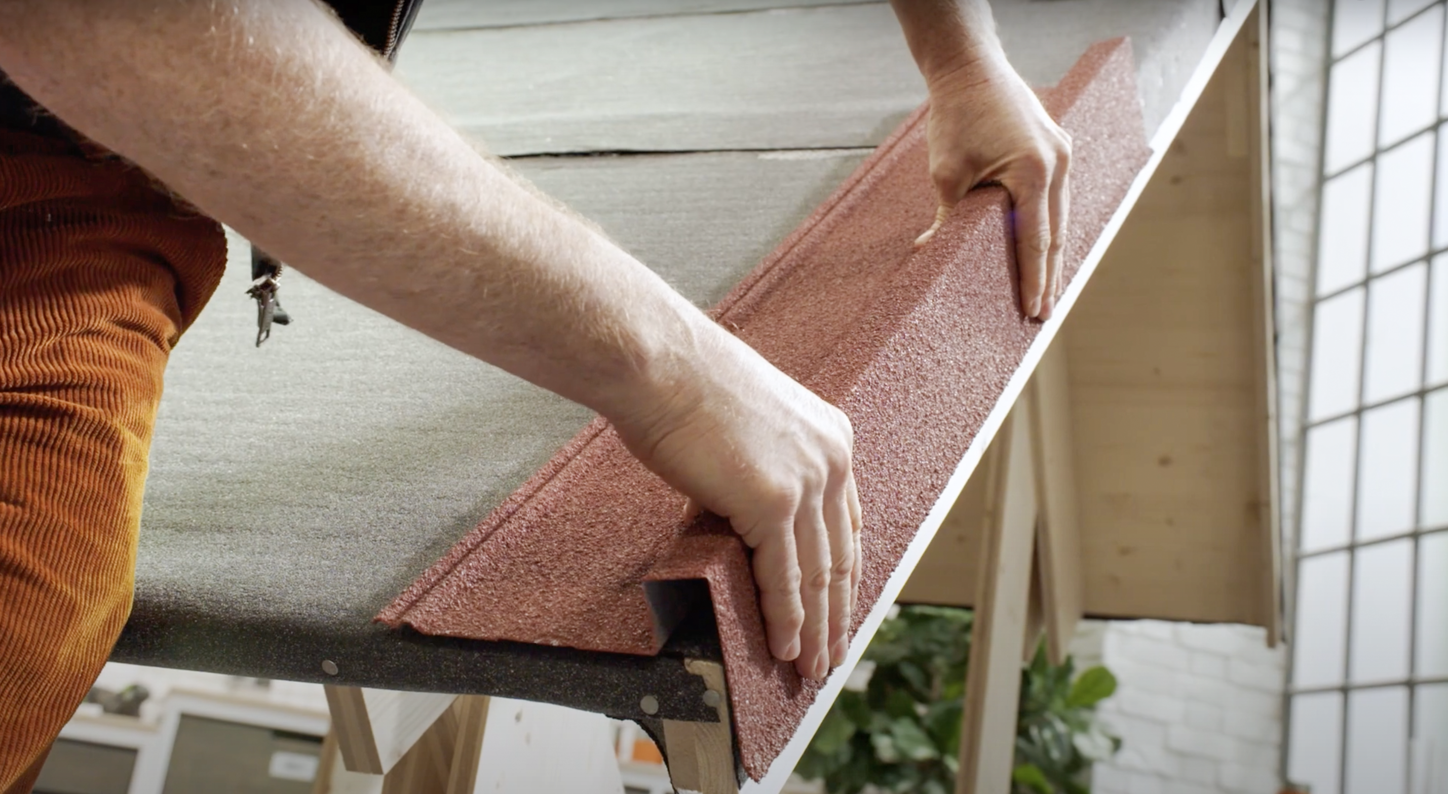 Handwerker legt platziert Ortgangprofile am Dachrand.