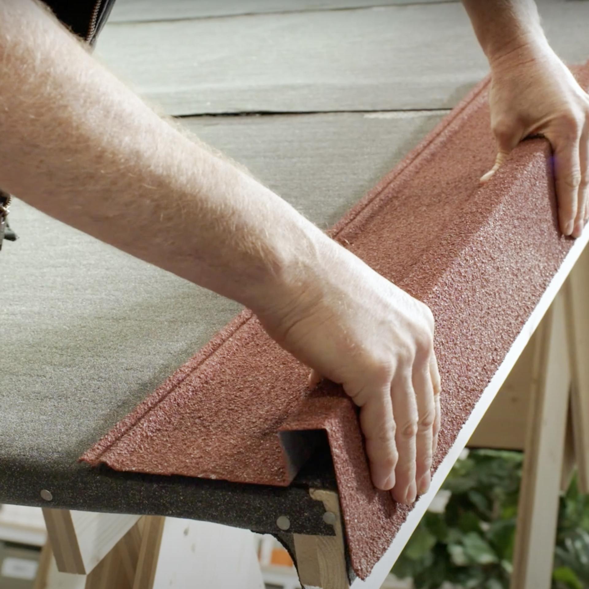 Handwerker legt platziert Ortgangprofile am Dachrand.