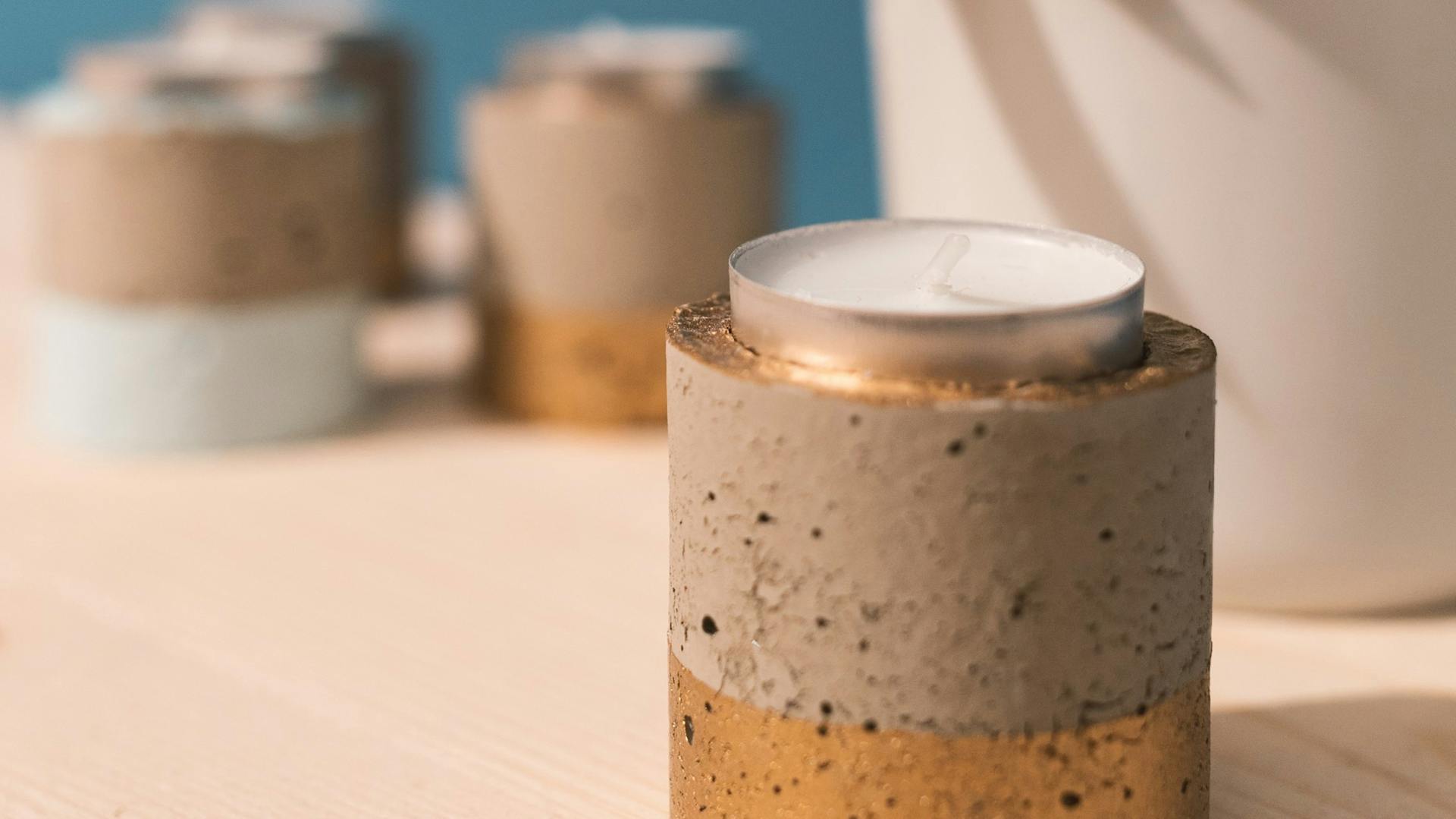 Teelichthalter mit Goldakzenten als Dekoration für Bad in Betonoptik