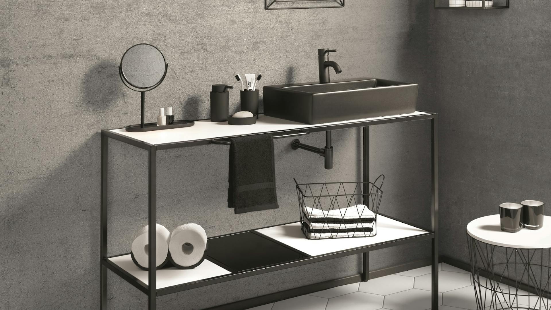 Bad in Betonoptik an Wände und Boden mit ebenerdiger Dusche, Badewanne und Waschtischen aus schwarzem Metall