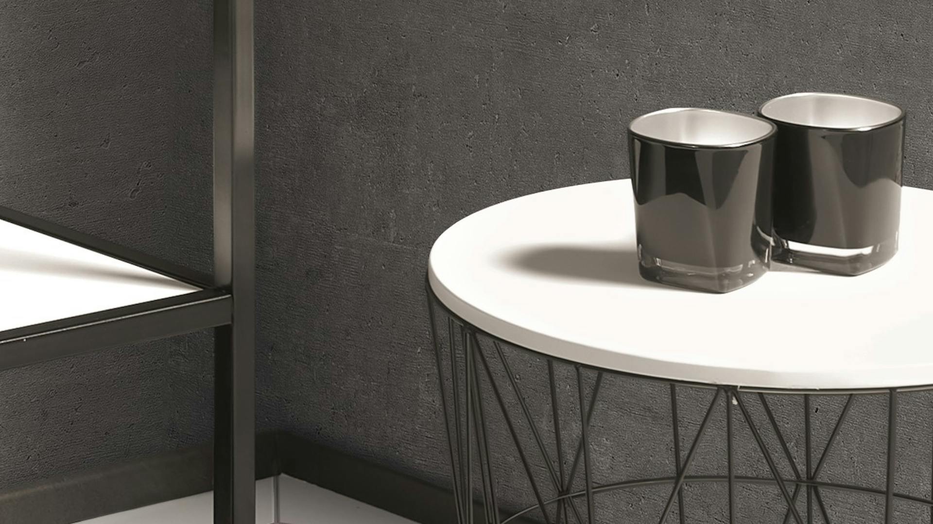 Beistelltisch aus schwarzem Metall mit Teelichtern als Dekoration in Badezimmer in Betonoptik