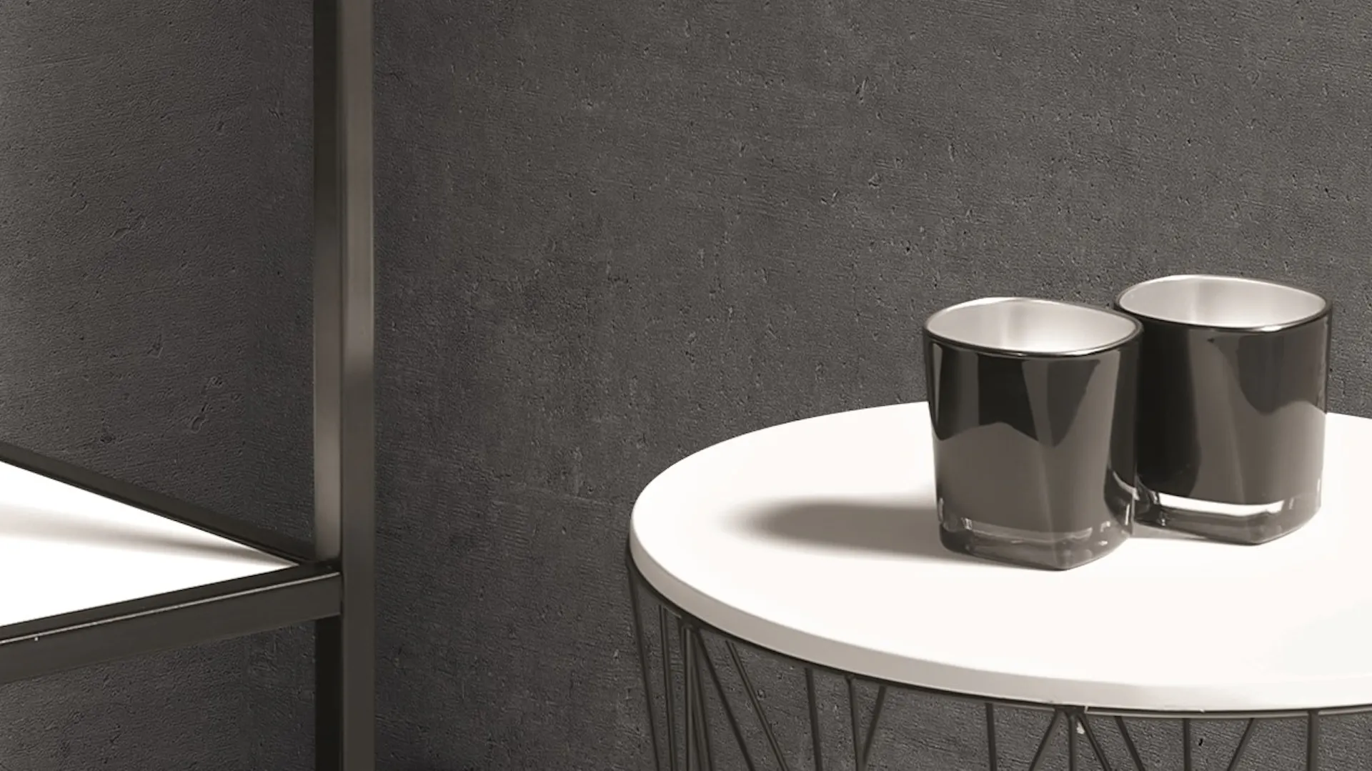 Beistelltisch aus schwarzem Metall mit Teelichtern als Dekoration in Badezimmer in Betonoptik