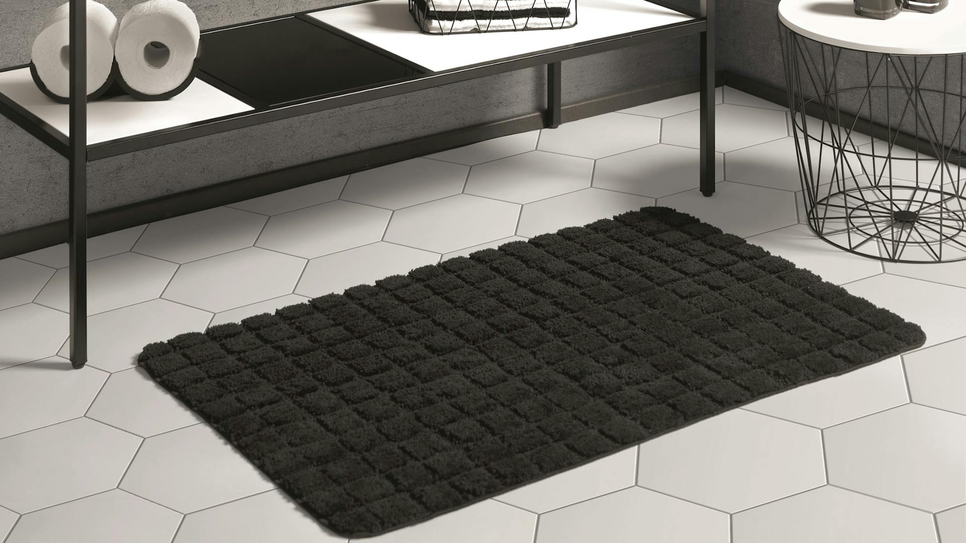 Badteppich auf wabenförmigen Fliesen von Bad in Betoptik