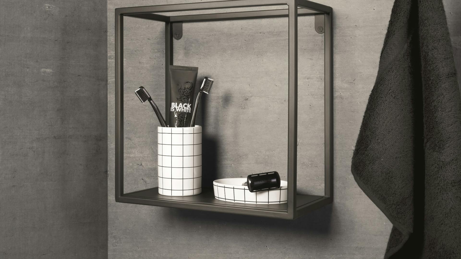 Kubisches Regal aus anthrazitfarbenem Metall mit Badaccessoires für Bad in Betonoptik