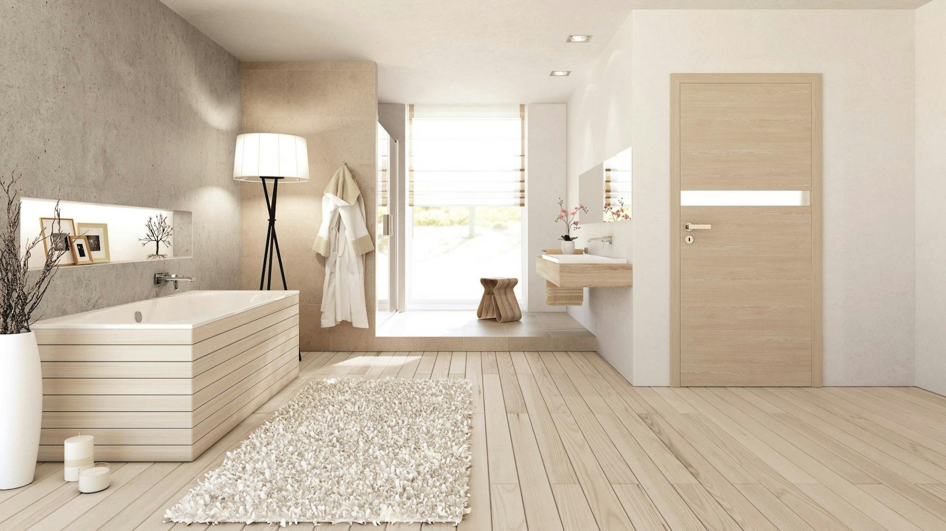 Badezimmer in Holzoptik mit Boden in heller Holzdielenoptik, verkleideter Badewanne, hölzerner Tür und beigen Dekoelementen.