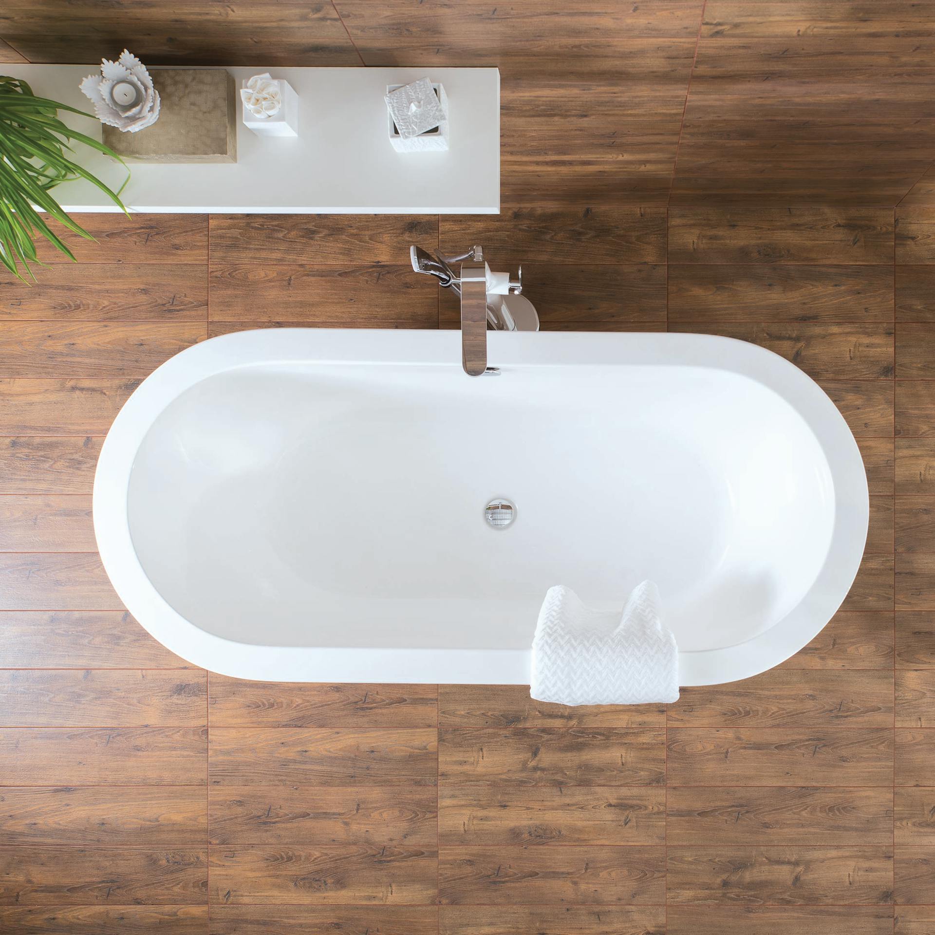Weiße freistehende Badewanne auf Holzfliesen