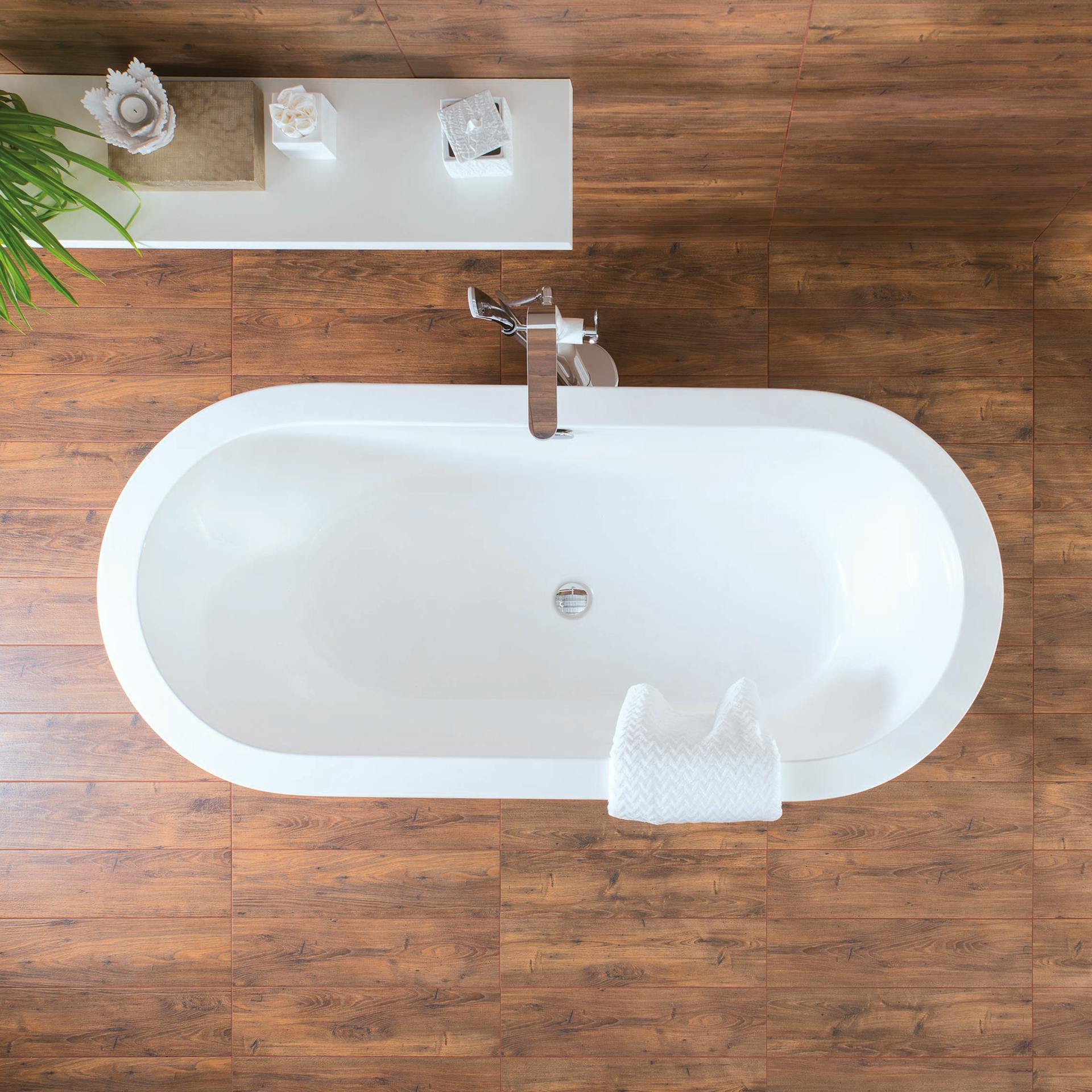 Weiße freistehende Badewanne auf Holzfliesen