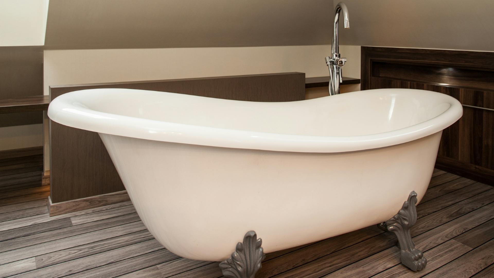 Weiße Doppelwaschbecken eingelassen in Marmorplatte. Zwischen den Becken steht eine grüne Pflanze.