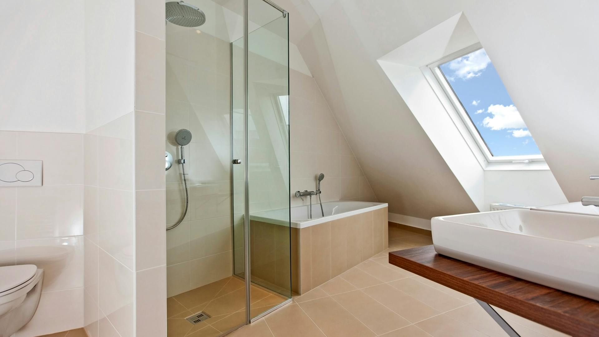Bad mit Duschkabine und Badewanne und Fenstern in der Dachschräge