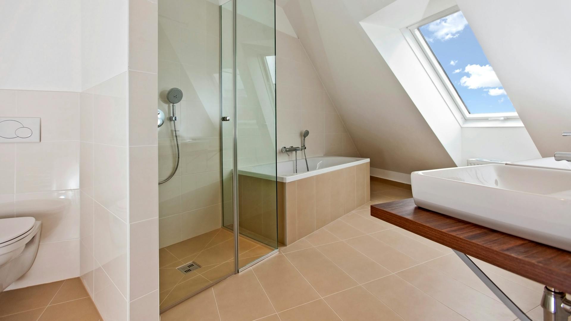 Bad mit Duschkabine und Badewanne und Fenstern in der Dachschräge