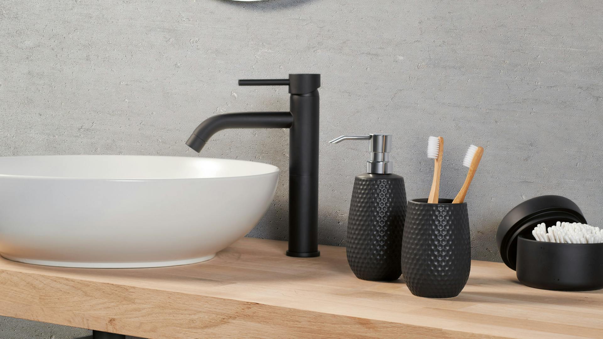 Ein schwarzer Wasserhahn am Waschbecken im Badezimmer.