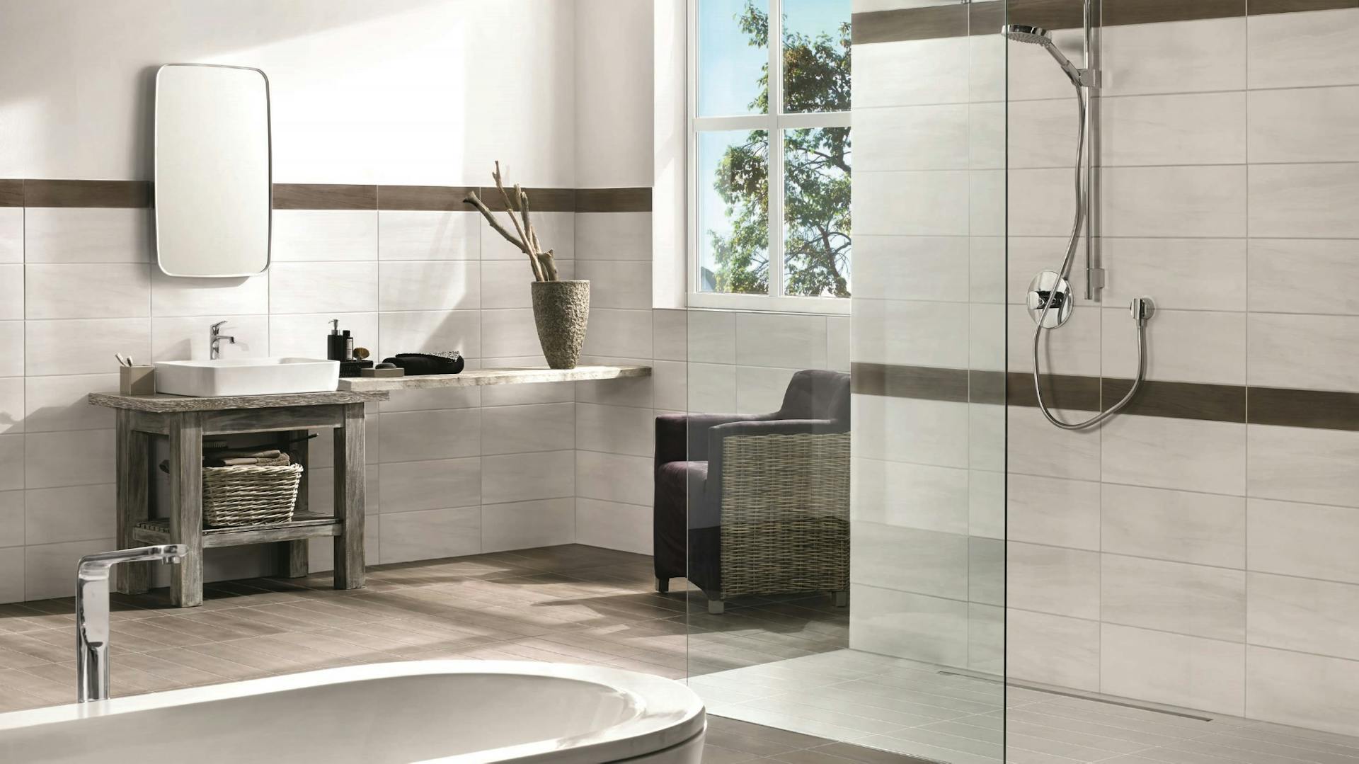 Modernisiertes Bad mit großen Fliesen, Regendusche und freistehender Badewanne.