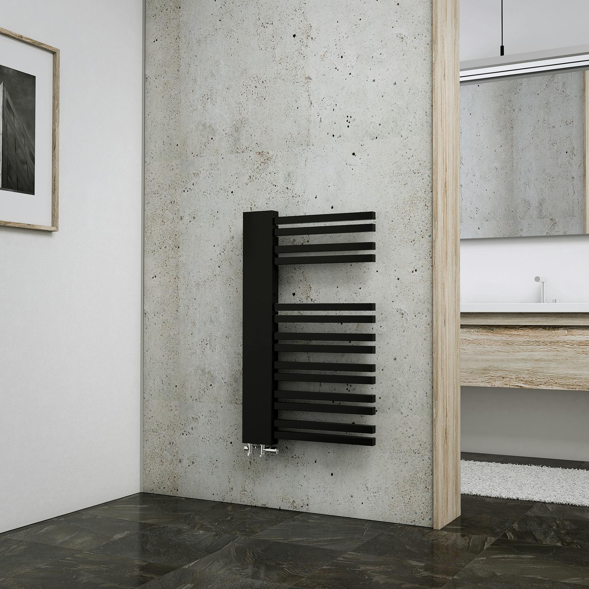 Fekete törölközőszárító radiátor szürke falon a fürdőszobában.