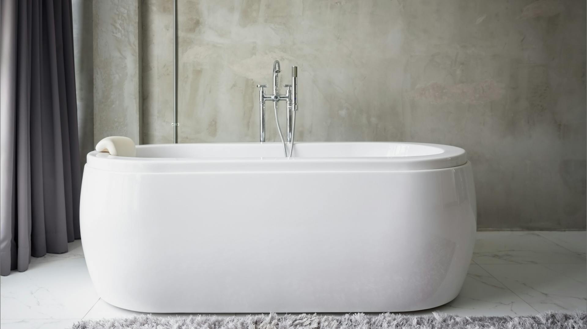 Fehér kád egy vakolt fal előtt.