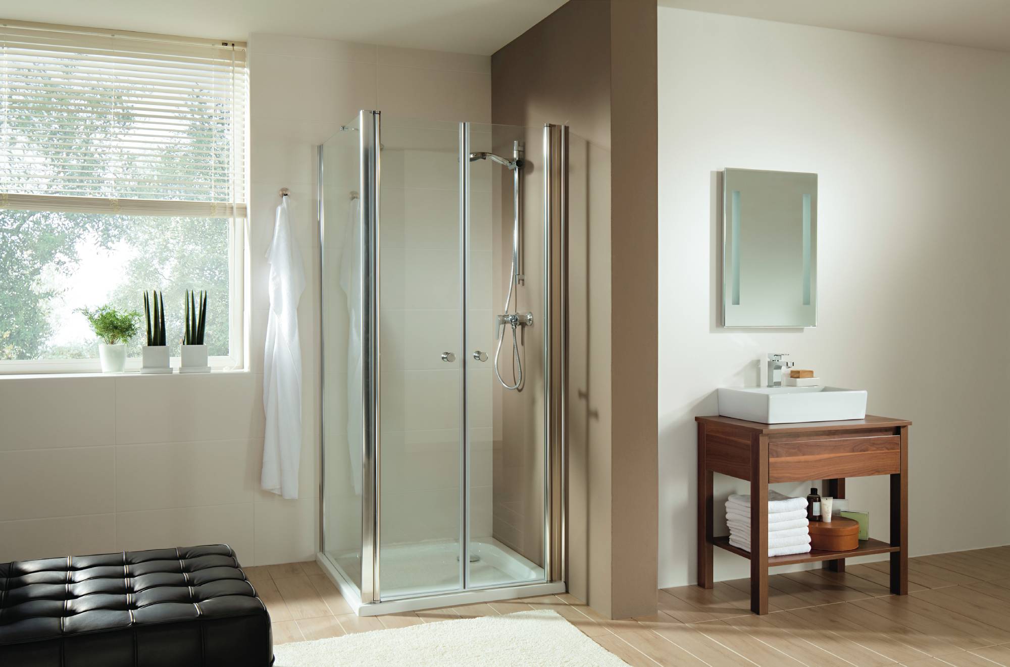 Doccia nell'angolo di un ampio bagno accanto a una cassettiera con specchio.