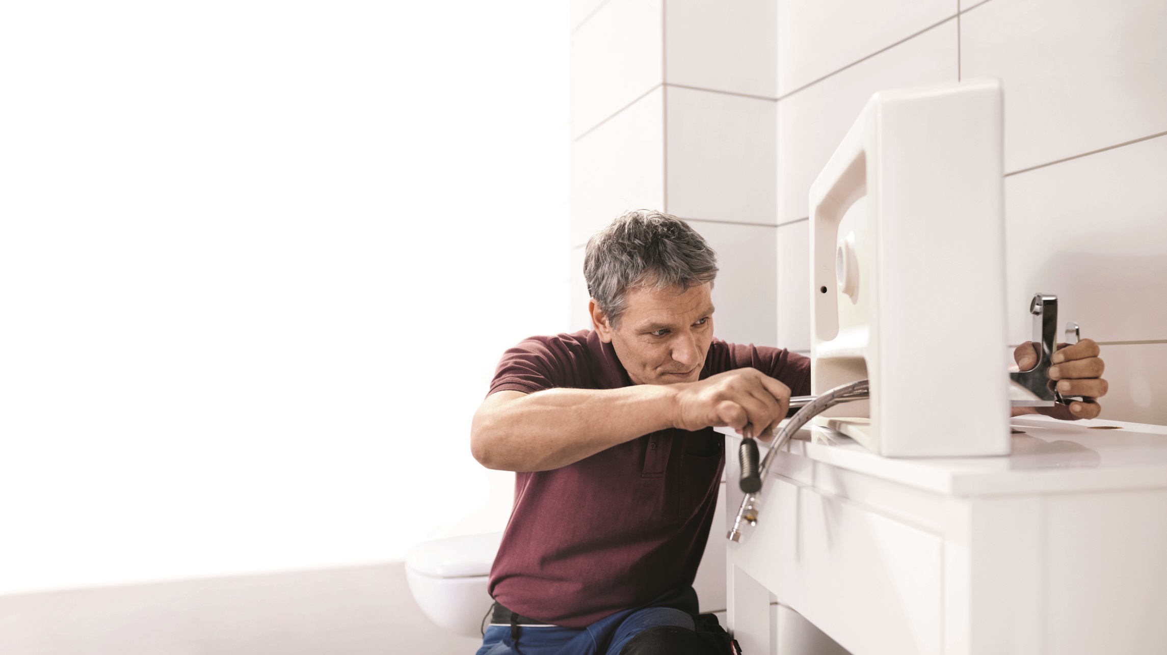 Una persona monta un nuovo lavabo in bagno.